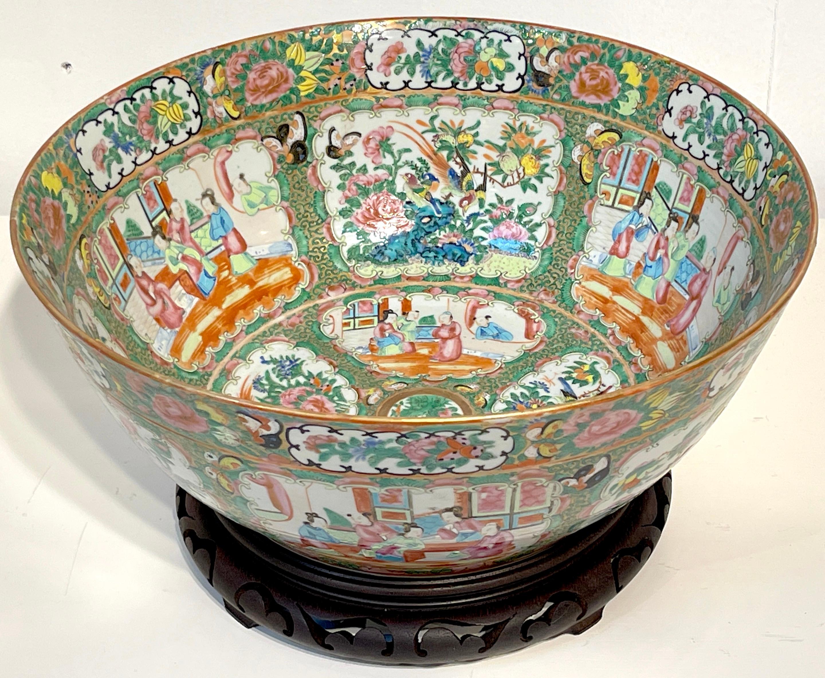 19th century Chinese Export Rose Medallion punch bowl, with stand 
China, circa 1860s, Later carved hardwood stand 20th Century 
Of generous size, bright and colorful, hand painted in the typical palette with gold tracing in the court ladies hair.
