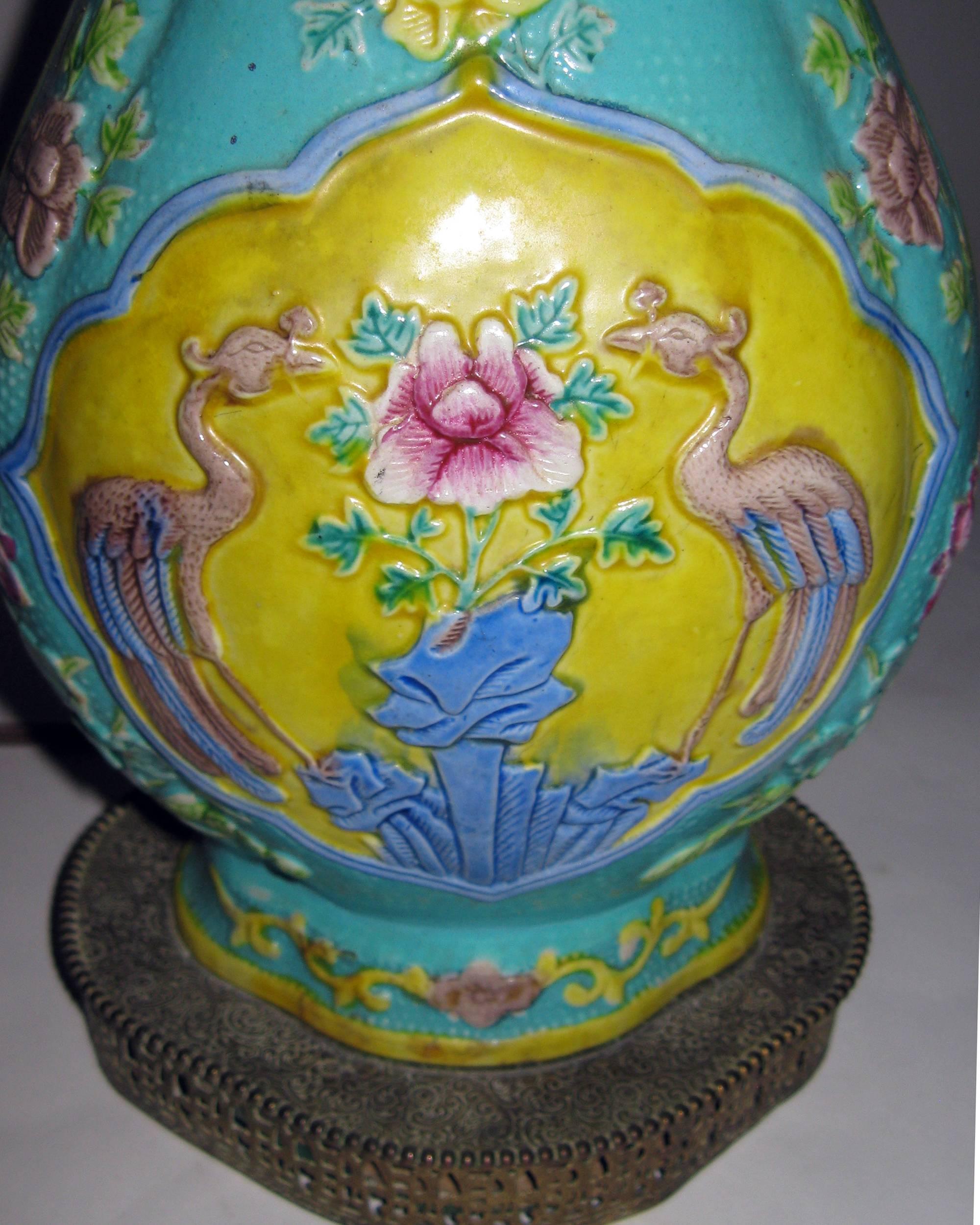 Dans la culture chinoise, les grues sont les symboles de la longévité. Ce vase en céramique a été transformé en lampe de table et présente une paire de grues avec des fleurs sur une base décorative en laiton filigrané, de jolies couleurs pastel