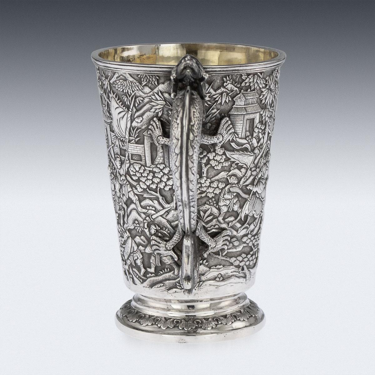 Antique 19th century Chinese export solid silver mug, of traditional shape and large size, the body is embossed with beautiful battle scenes in relief depicting Chinese warriors fighting amongst village landscape, double walled and richly gilt, the