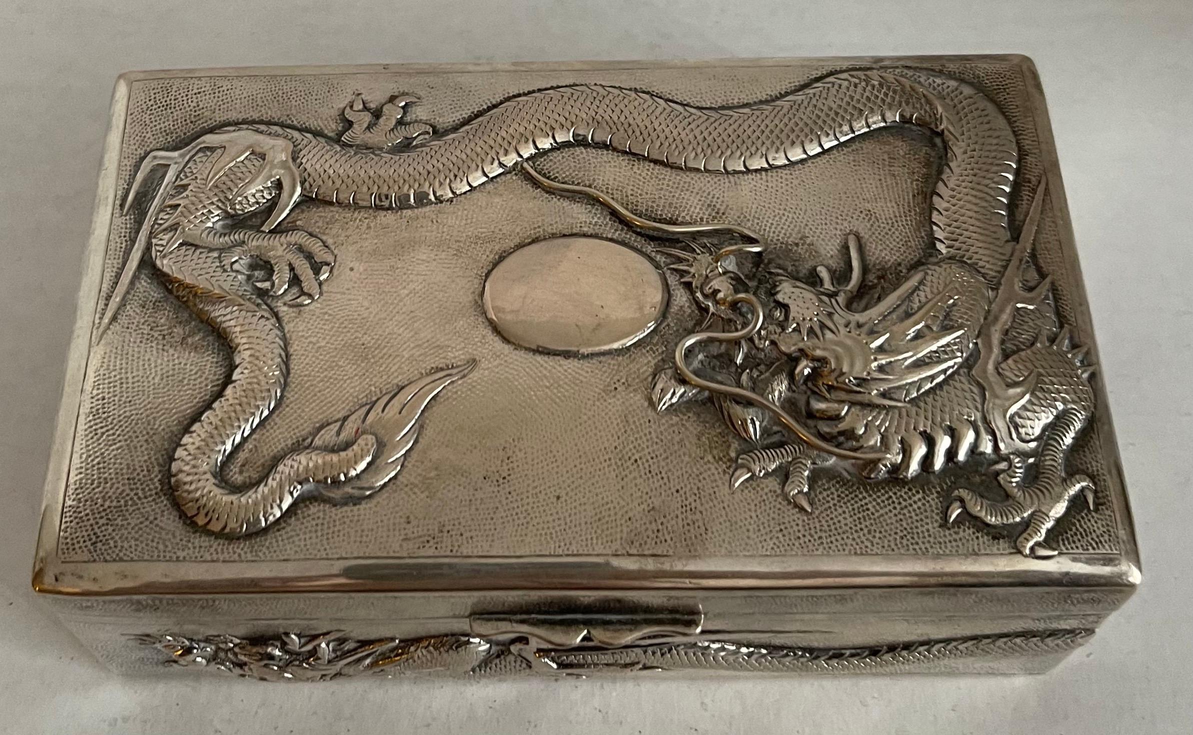 Late 19th century, circa 1890 Chinese export silver rectangular box. Hand engraved repoussè dragons. Wood lined. Makers mark on the underside.