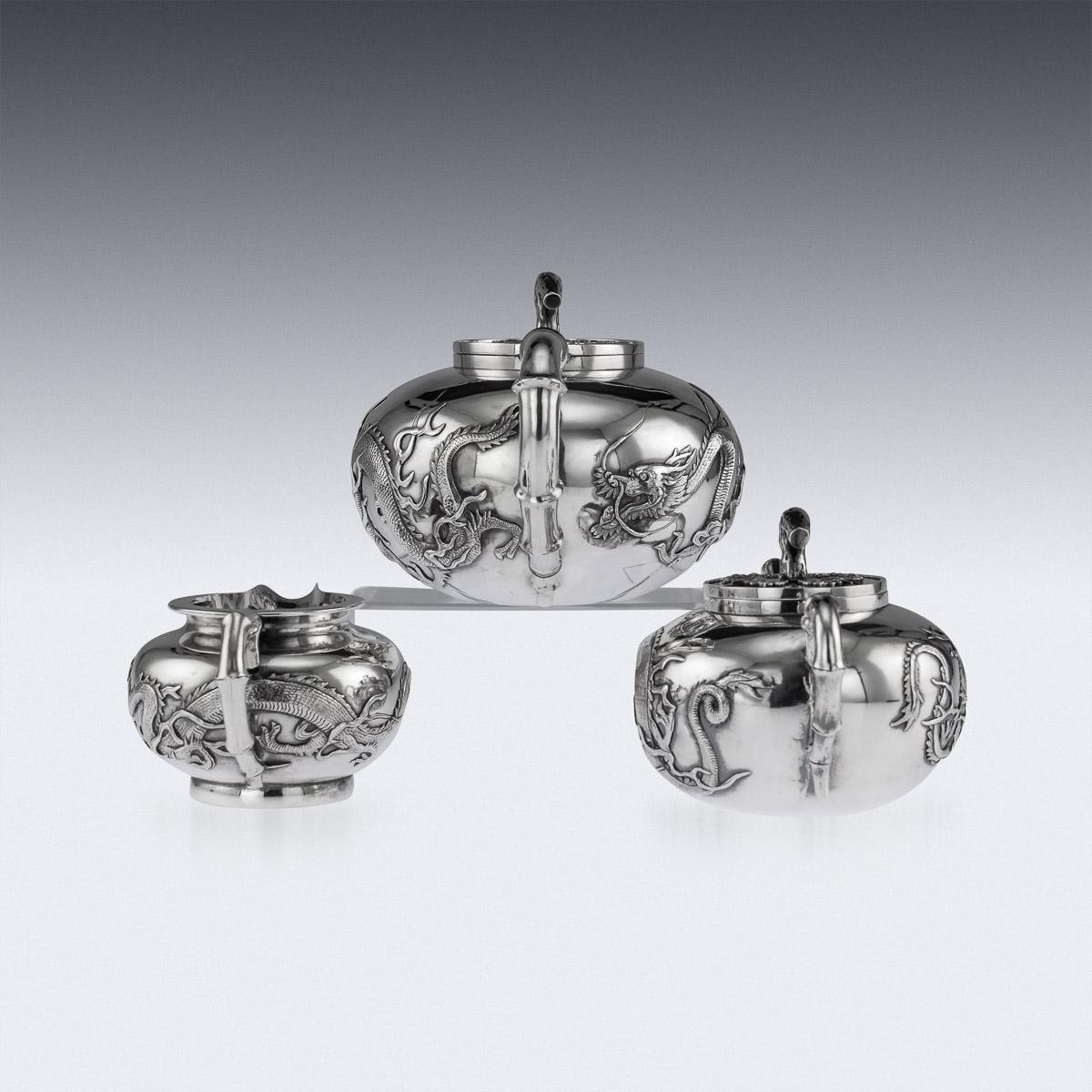Antique late 19th century Chinese export solid silver three-piece tea set, comprising of teapot, sugar bowl and milk jug, each spherical body applied with exquisite dragons in relief, spout, handle and feet modelled as a bamboo branch and lids