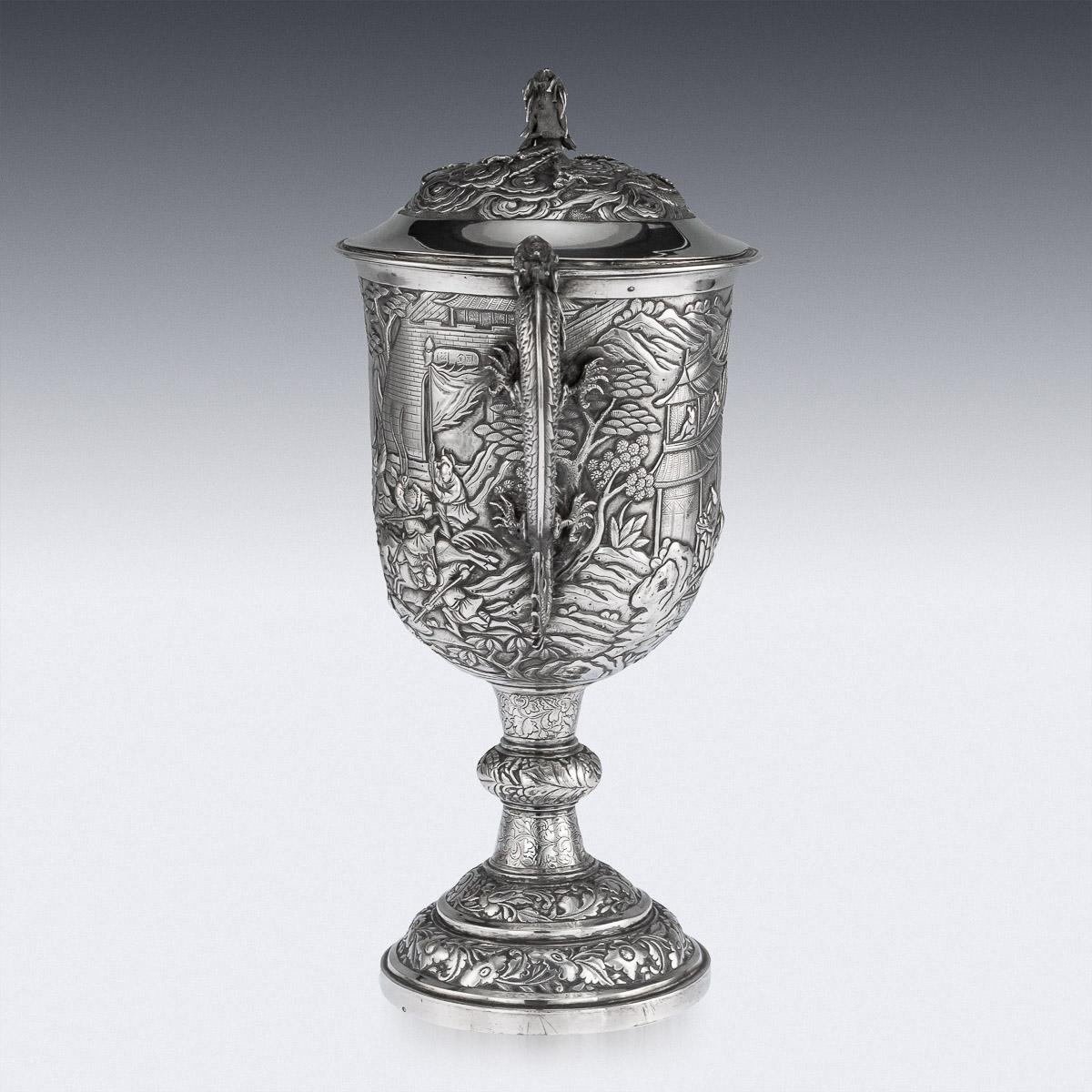Antique mid-19th century Chinese export solid silver presentation cup and cover, of traditional shape and large size, the body is embossed with beautiful battle scenes in relief depicting Chinese warriors fighting amongst village landscape, applied