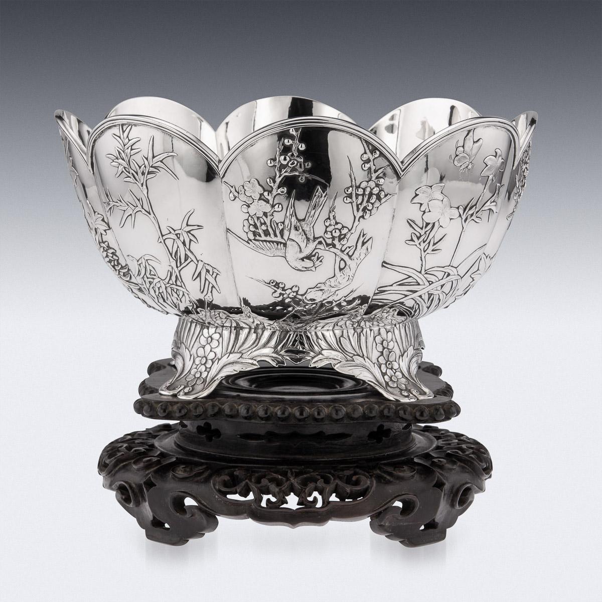 19th century Chinese solid silver decorative fruit bowl, of traditional round form, with a shaped arched rim, standing on four spreading feet, with floral decoration along the bottom. The decoration is crisp and detailed, decorated with a continuous