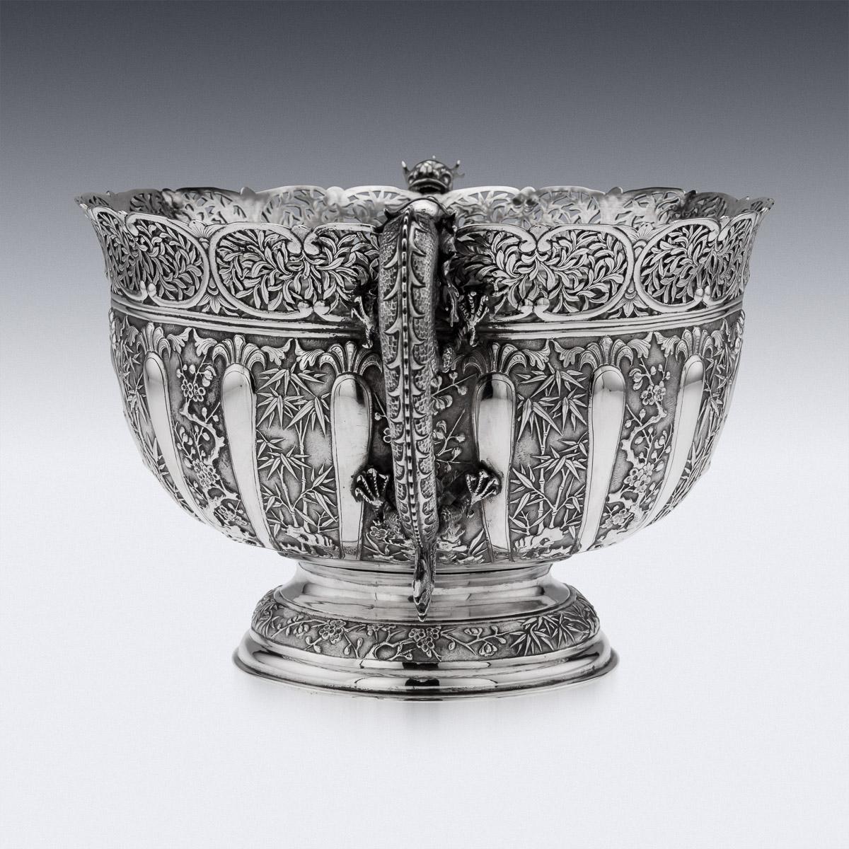 19th century Chinese silver decorative dragon bowl, of round form on a dome shaped foot. The body repoussé decorated with blooming cherry tree branches, dense bamboo and flitted bands, each side with leaf capped cartouches, one engraved with very