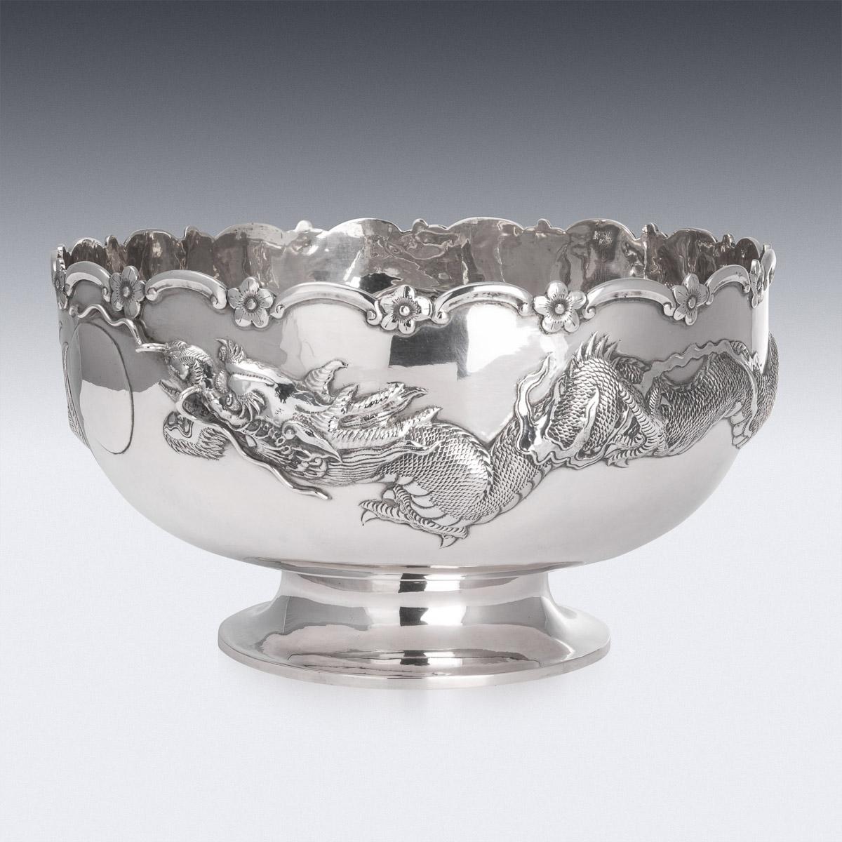 Antique late-19th century Chinese export solid silver bowls, very large and of traditional form, hand chased with a large dragon in relief chasing the pearl of wisdom, the design is particularly well modelled and detailed, the growling face applied