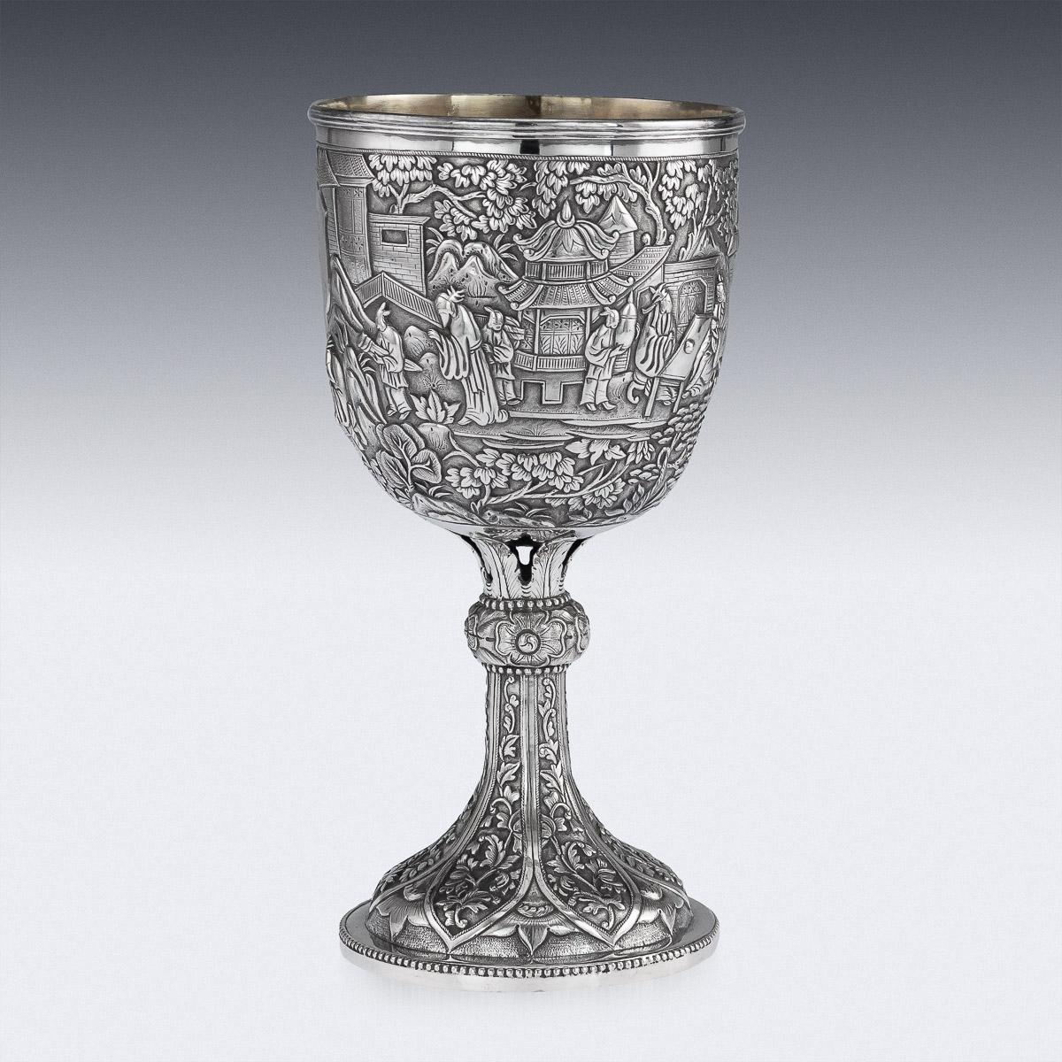 Antique 19th century Chinese export solid silver wine goblet, impressive and exceptionally fine quality, richly gilt inside, fully chased and embossed with a dense village scenes and receptions before scholars & nobility, cup resting on a highly