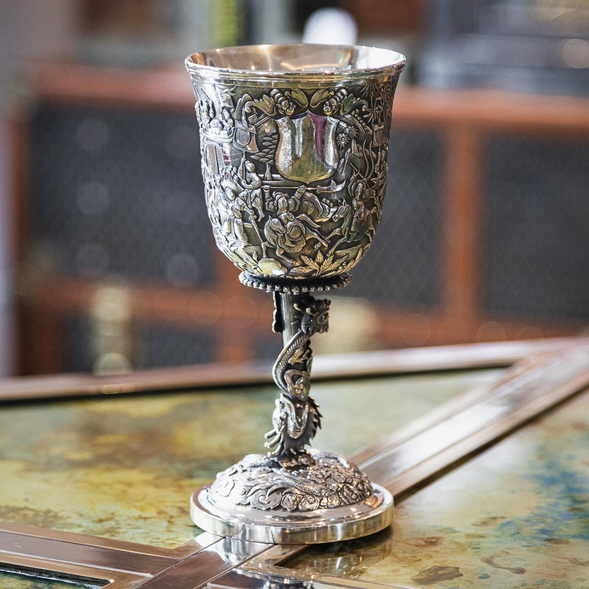 Antique late-19th century Chinese export solid silver wine goblet, impressive and exceptionally fine quality, fully chased and embossed with a dense battle scenes and receptions before scholars & nobility, cup resting on a highly decorative