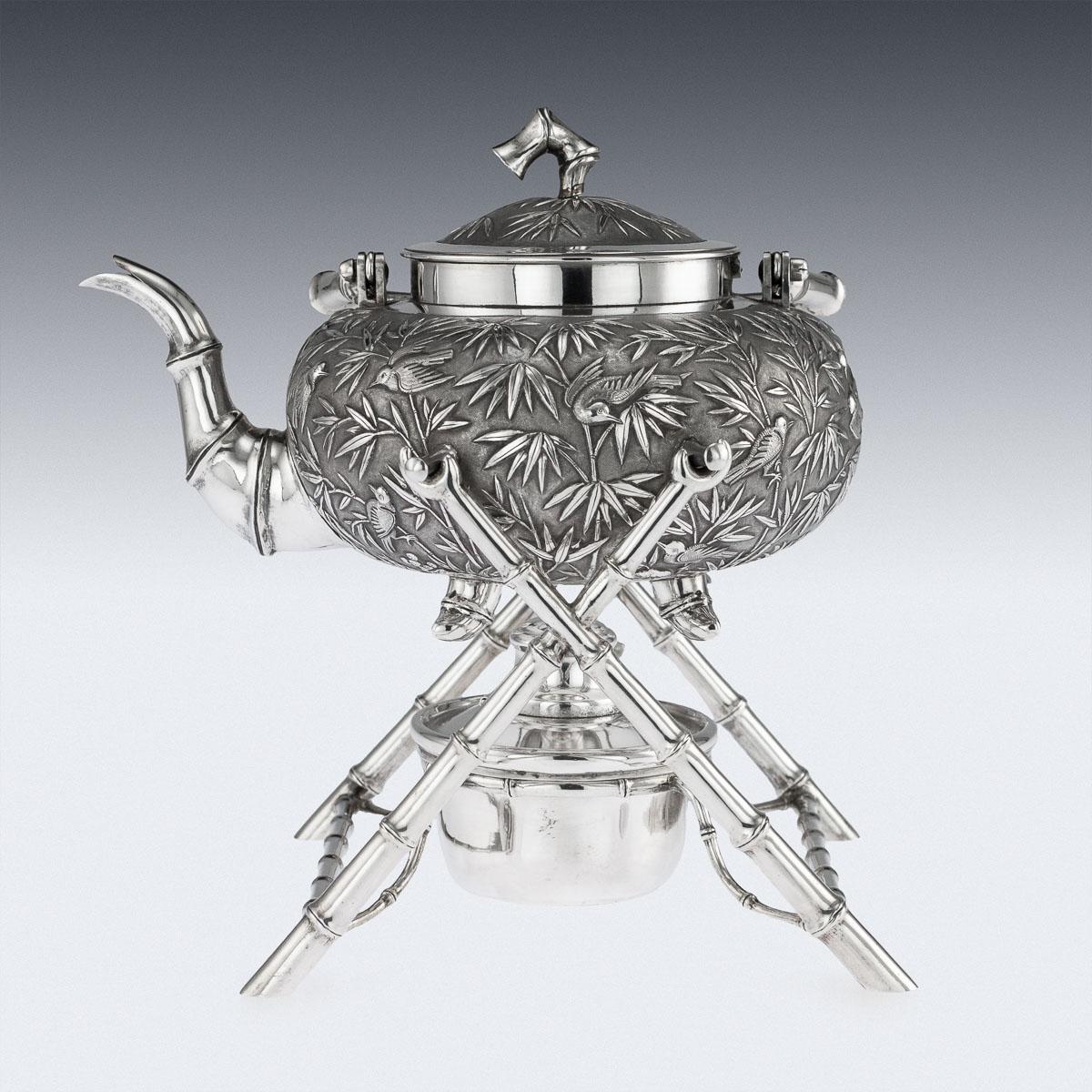 Antique 19th century Chinese export solid silver tea kettle, chased in relief with floral bamboo decoration and various birds perching on tree branches, the domed lids mounted with bamboo finial. The kettle is suspended on a stylized,