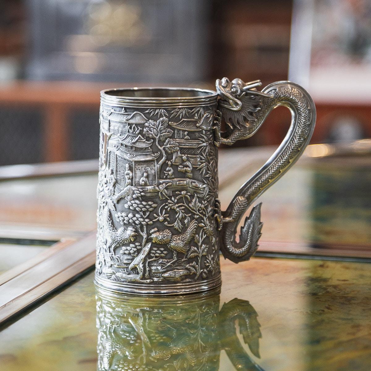 Antique late 19th century Chinese export solid silver mug, of traditional shape and large Size, the body is embossed with beautiful nobility scenes, perched cockerels amongst foliage, double walled, the front centering with an engraved shield shaped