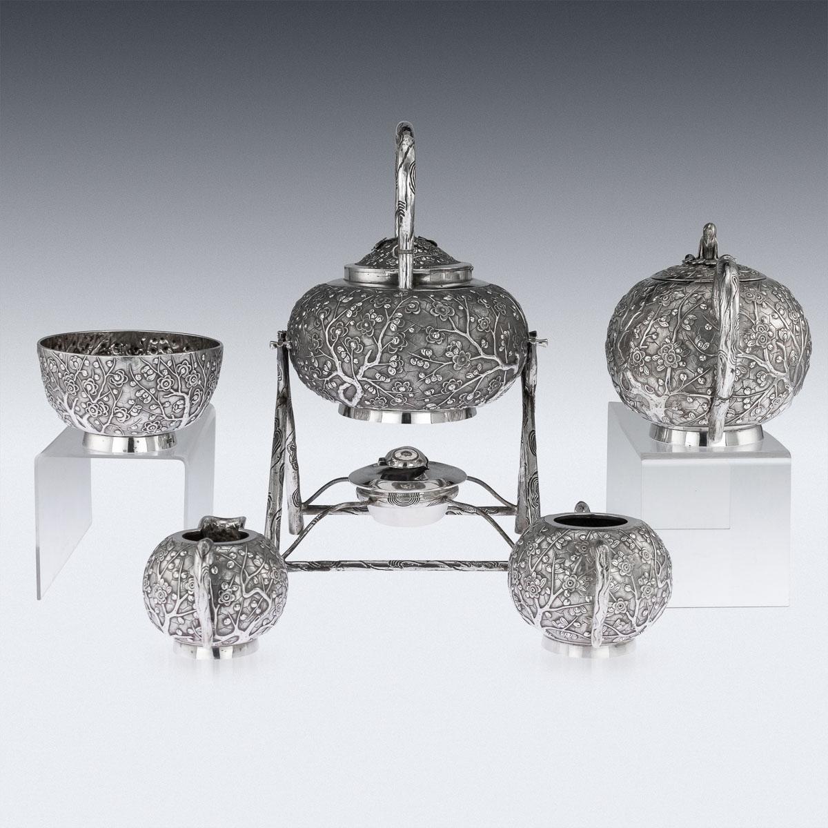 Antique 19th century Chinese export solid silver tea service, impressive and exceptionally fine quality, consisting of a hot water kettle on stand, teapot, waist bowl, sugar bowl and cream jug. The set is ball-shaped, decorated with repoussé prunus