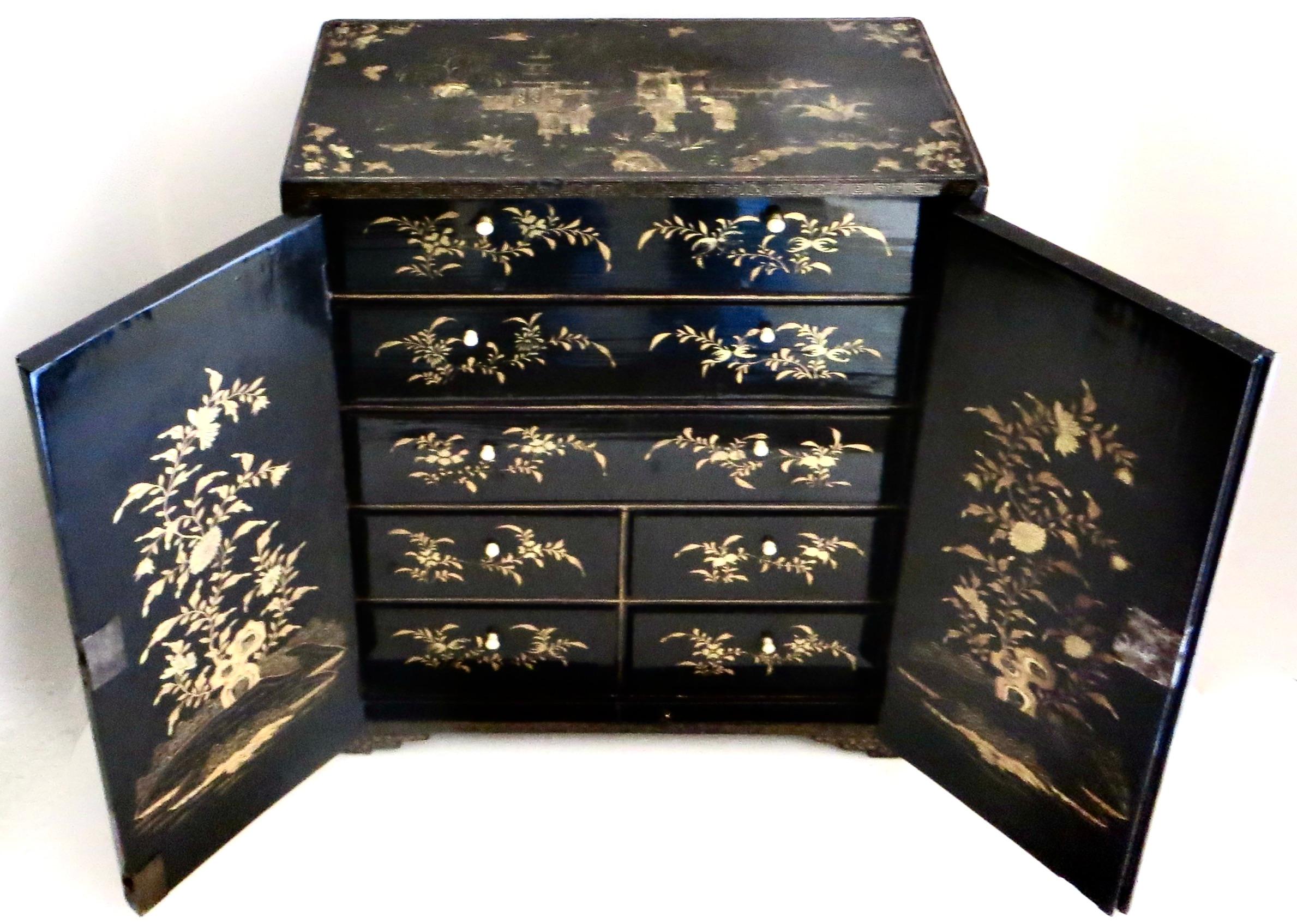 Chinoiserie hand painted 19th century Chinese export jewelry cabinet circa 1880; is fronted by a pair of raised panel double doors; decorated in gilt with scenes of Chinese figures, floral borders, indigenous trees, with pavilion pagoda like