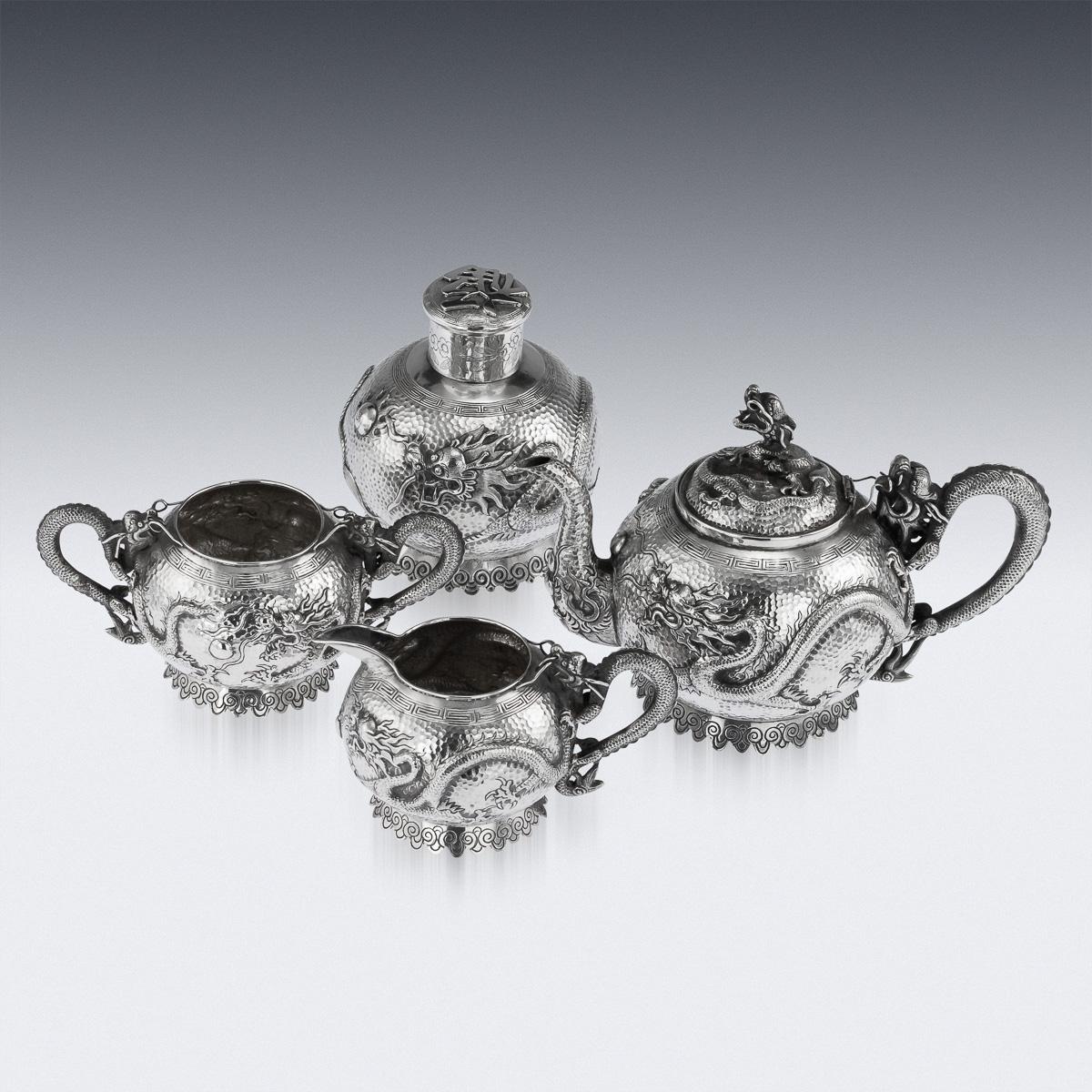 Antique 19th century Chinese Export solid silver four piece tea set, comprising of teapot, tea caddy, sugar bowl and milk jug, each spherical body is beautifully embossed with dragons chasing the flaming pearl of wisdom on hand hammered surface,