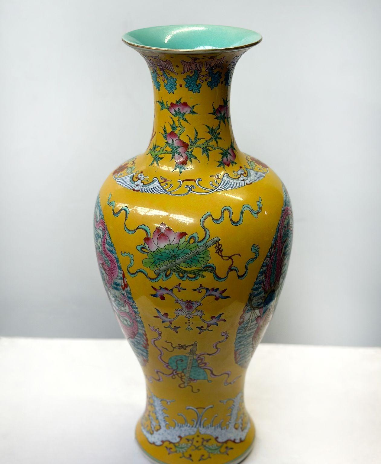 Traditional Chinese Famille Jaune porcelain vase in baluster form with beautiful botanical depictions along with dragon figures all around and other mythical creatures surrounding the piece. The vase is made of a bright yellow color and red, blue,