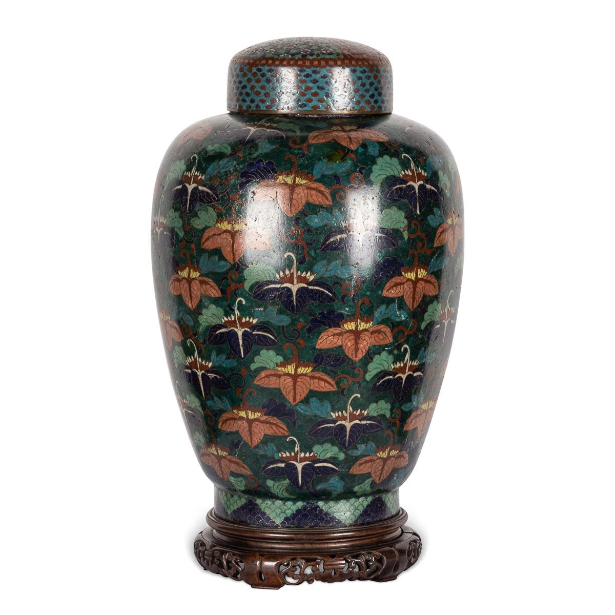 Antique pair of 19th Century Chinese cloisonné enamel famille noir ginger jars featuring a black background with an abundance of verte colour foliage and flowers. Standing on a fitted carved wood stand. Rare colour, in excellent condition with