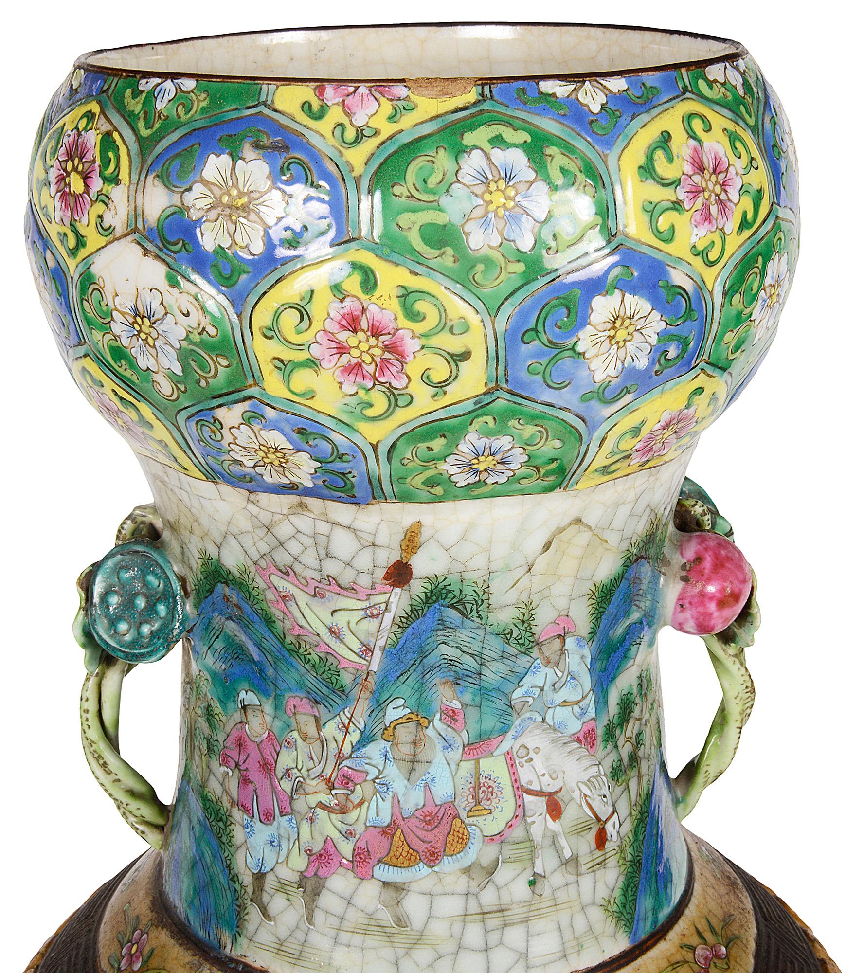 Un très impressionnant et décoratif vase / lampe en faïence de la Famille Rose du 19ème siècle. Décoration bronzée à motif classique, poignées en forme de feuilles et de baies. Scènes peintes à la main représentant des guerriers partant au combat,