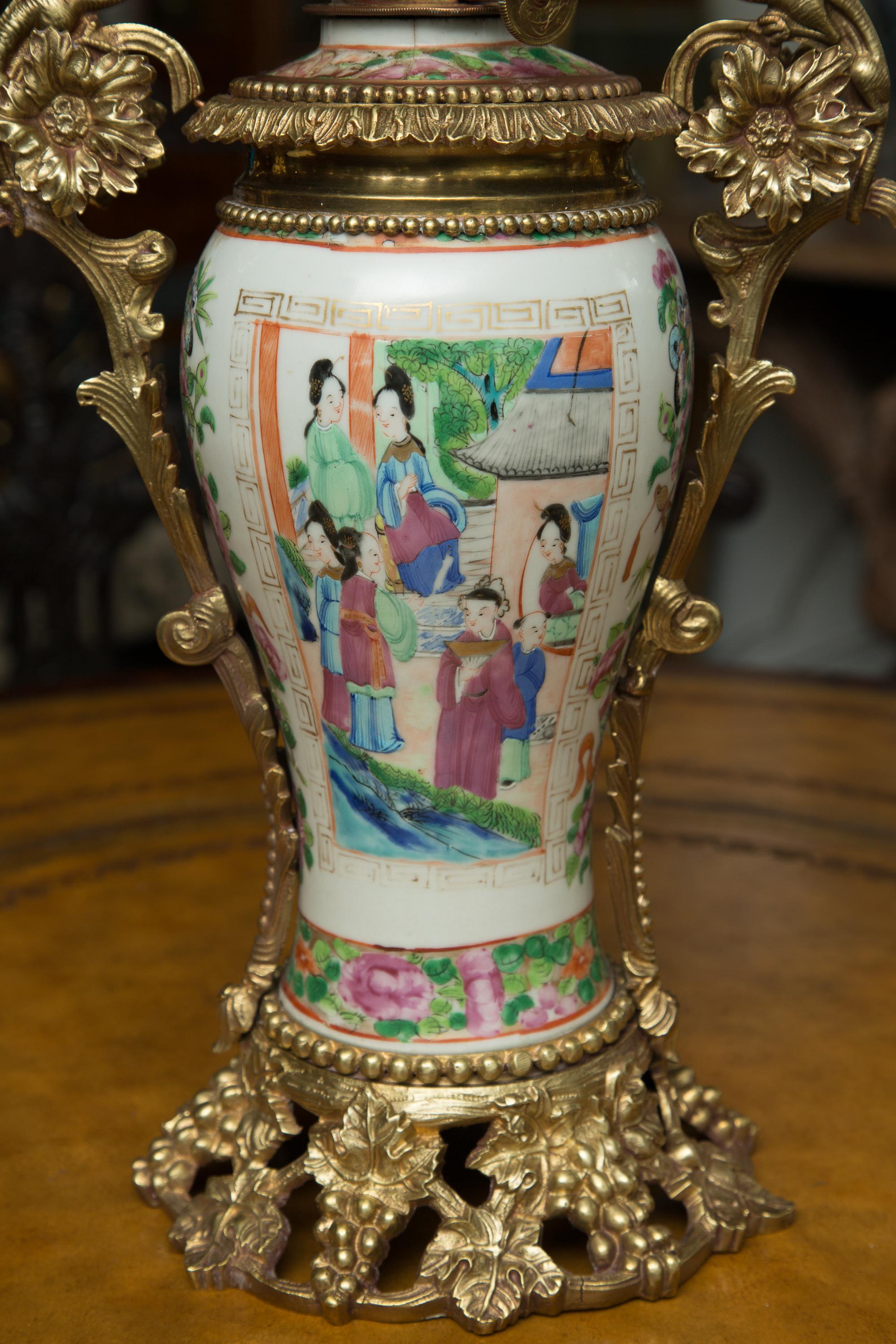 This is a lovely Chinese Famille Rose vase decorated with a centralized scene depicting Classic Chinese figures and floral motif, electrified as a lamp and ensconced in ornate gilt metal mounts, 19th Century.