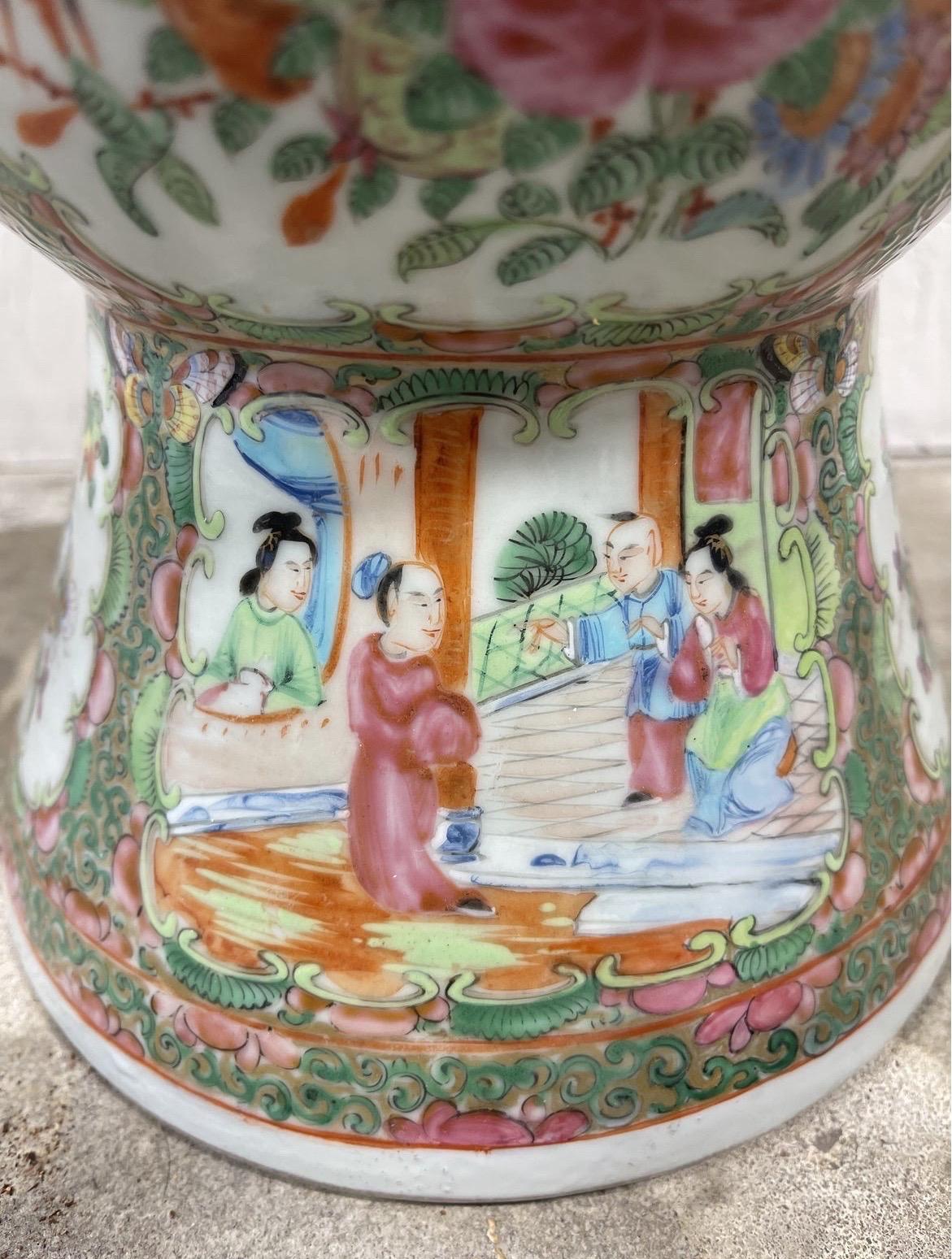 An antique 19th century famille rose medallion gu vase with figural windows to body and bright colors.