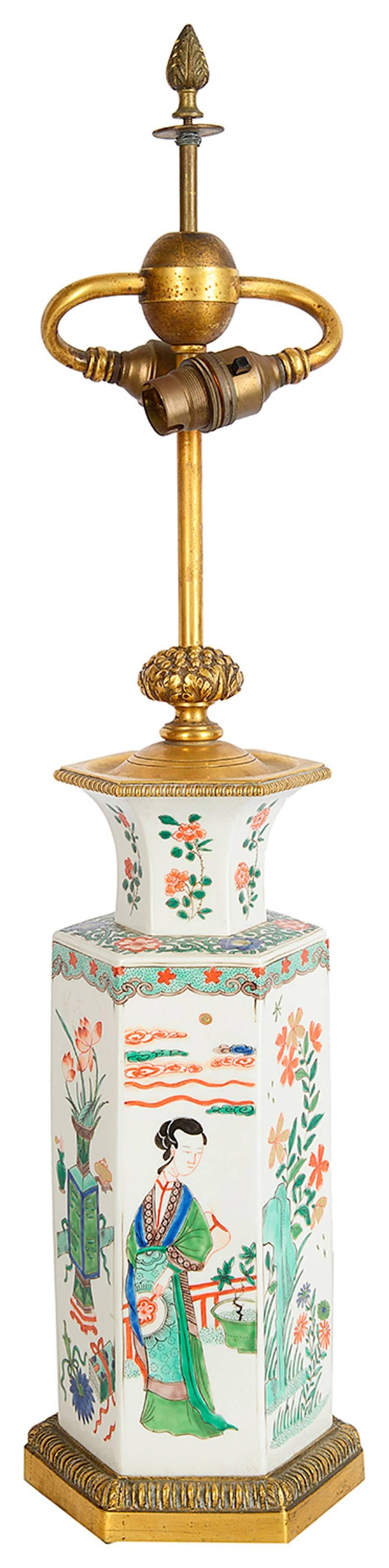 A good quality 19th century Chinese famille verte style (Samson) hexagonal vase, having scenes of girls amongst flowers, leaves and vases, mounted on a gilded ormolu base.