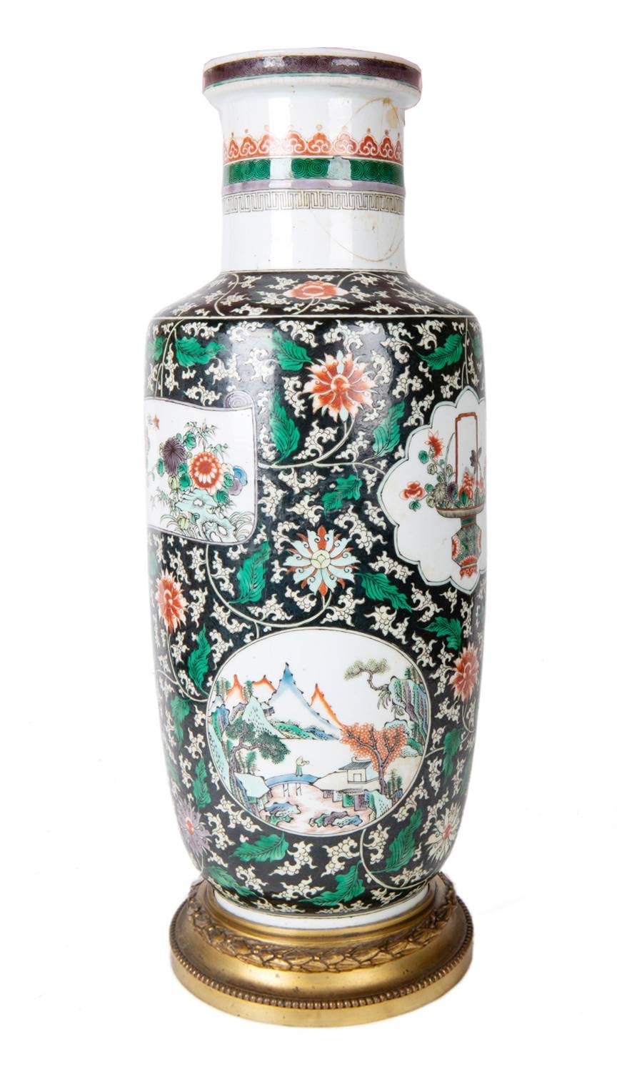 A very good quality mid-19th century Chinese Famille verte vase / lamp. Having a black and green ground with classical flower and leaf decoration. The inset painted panels depicting picturesque mountain scenes with builds and baskets of flowers.