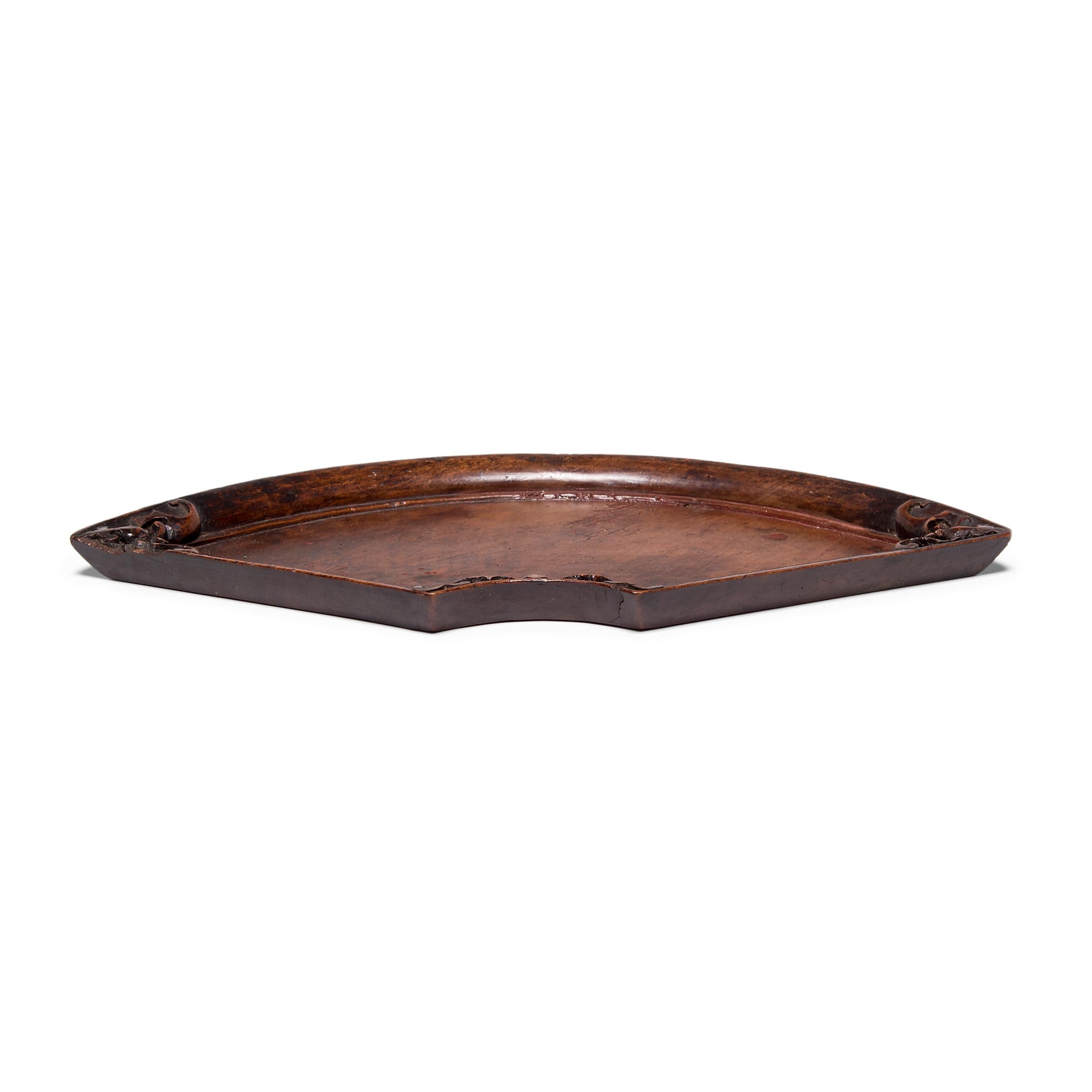 Hand-carved from birchwood, this exquisite tray is an excellent example of 19th century art from China's Shanxi province. The tray is shaped in the form of a paper fan, an accessory that emerged in China over 3,000 years ago and gained symbolic