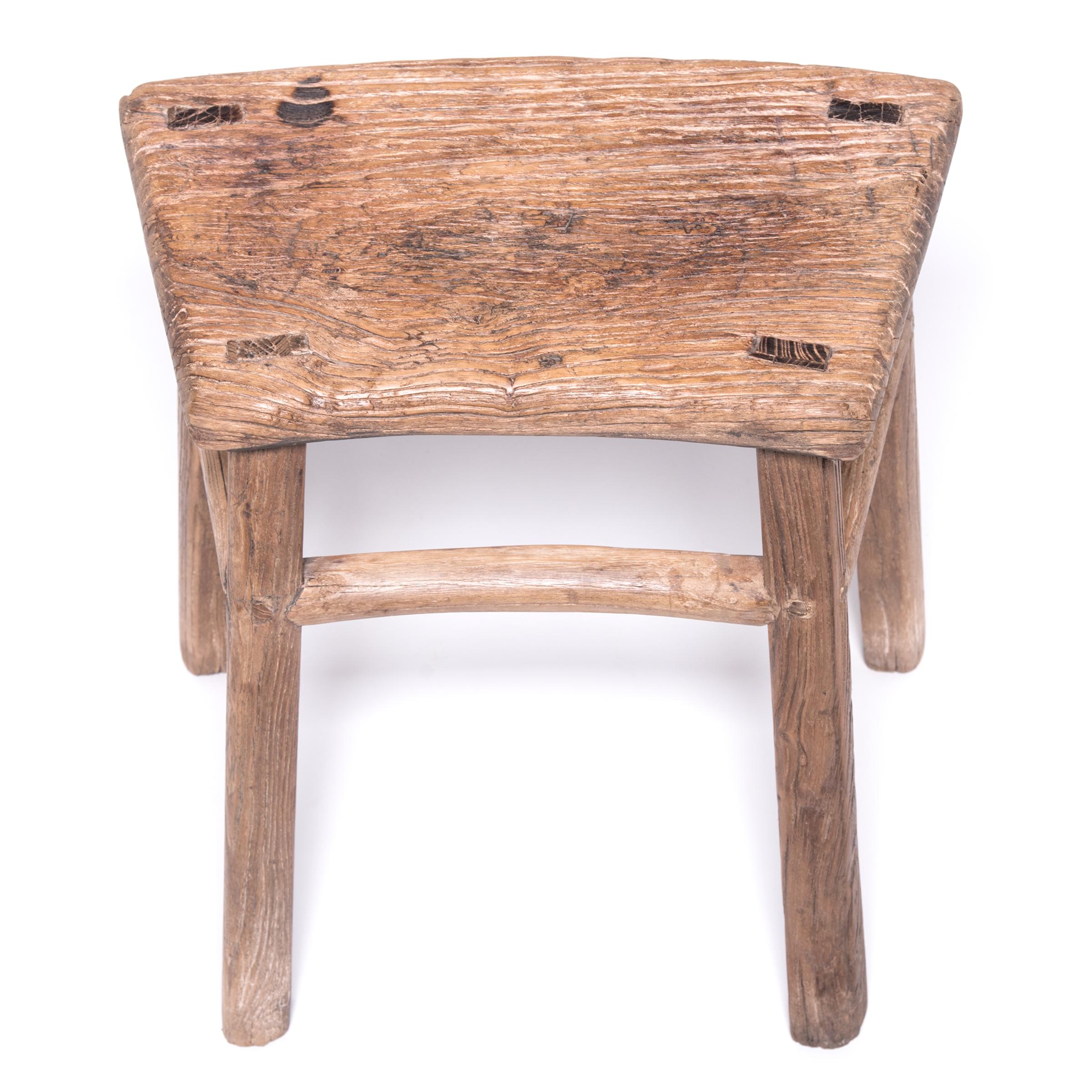 Crafted by an artisan in China's Hebei province, this mid-19th century stool has aged beautifully with time, developing a rich texture that calls to be touched. The stool's traditional mortise-and-tenon joinery adds charming detail to the simple