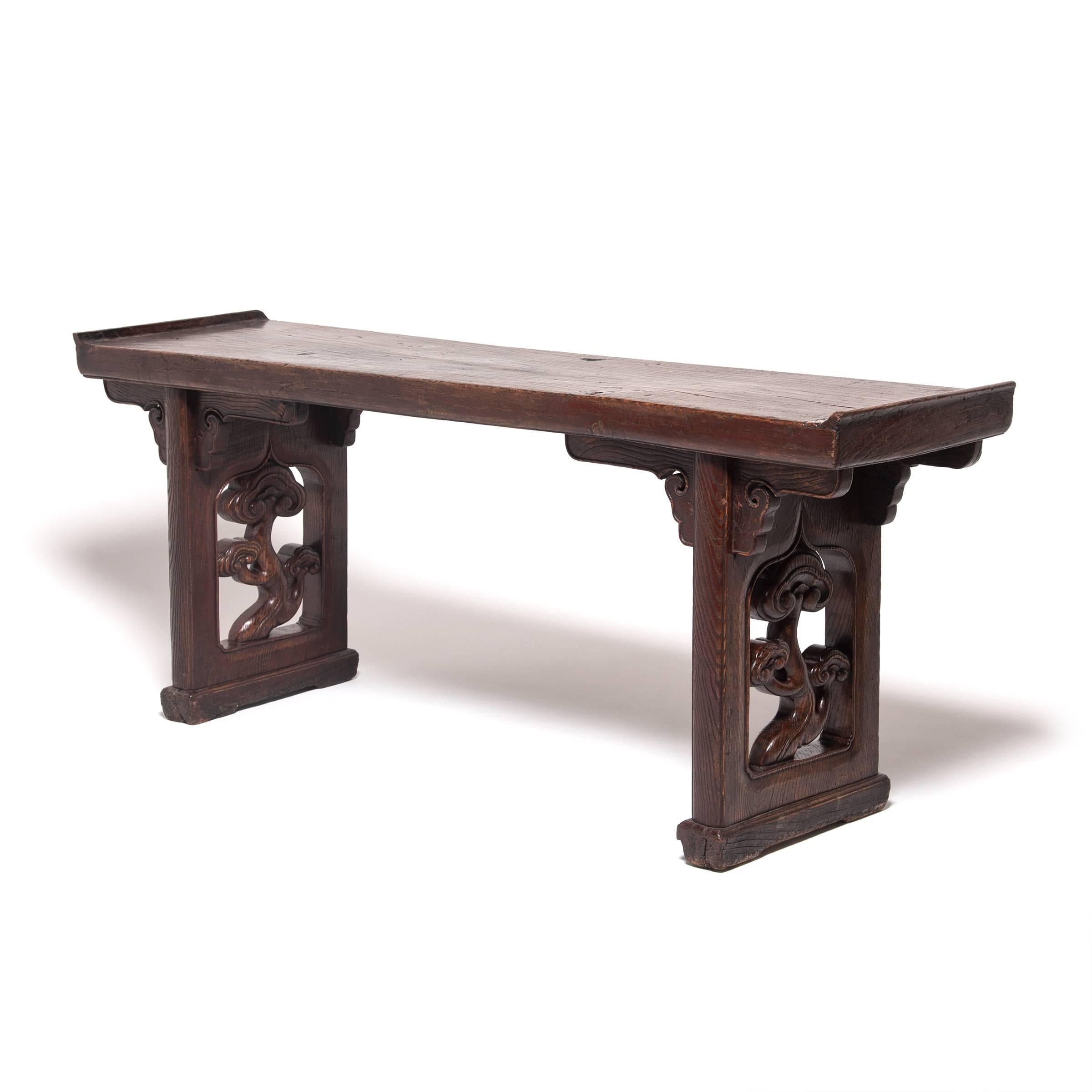 This monumental early 19th century flanked top altar table from China's Shanxi province is notable for its robust traditional style. The top is carved from a solid plank of elmwood timber and the thick side panels are carved with uniquely smooth and