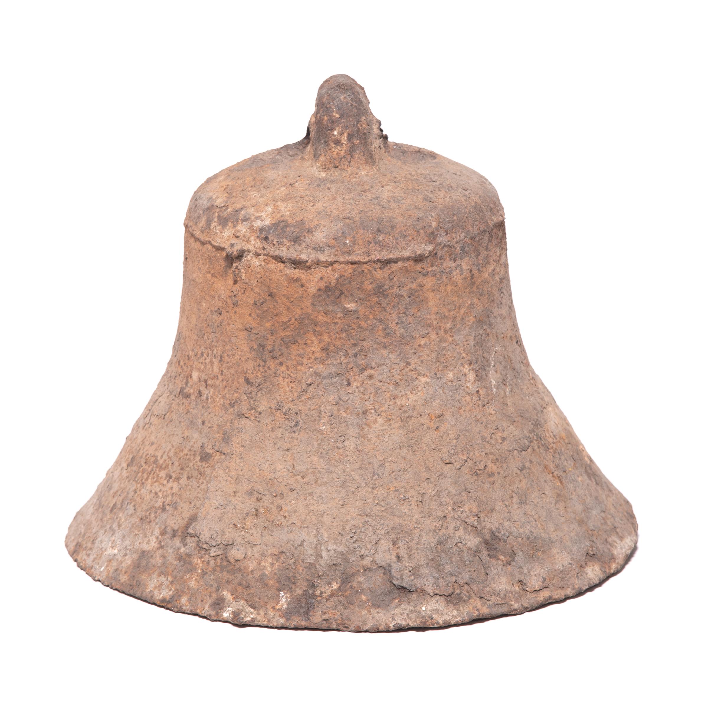 This rustic, 19th century iron bell once pealed in celebration or gave notice of important events in a town in northern China. The flare of this bell gives it a unique sculptural form, perfectly complemented by its rusted, textured surface. The