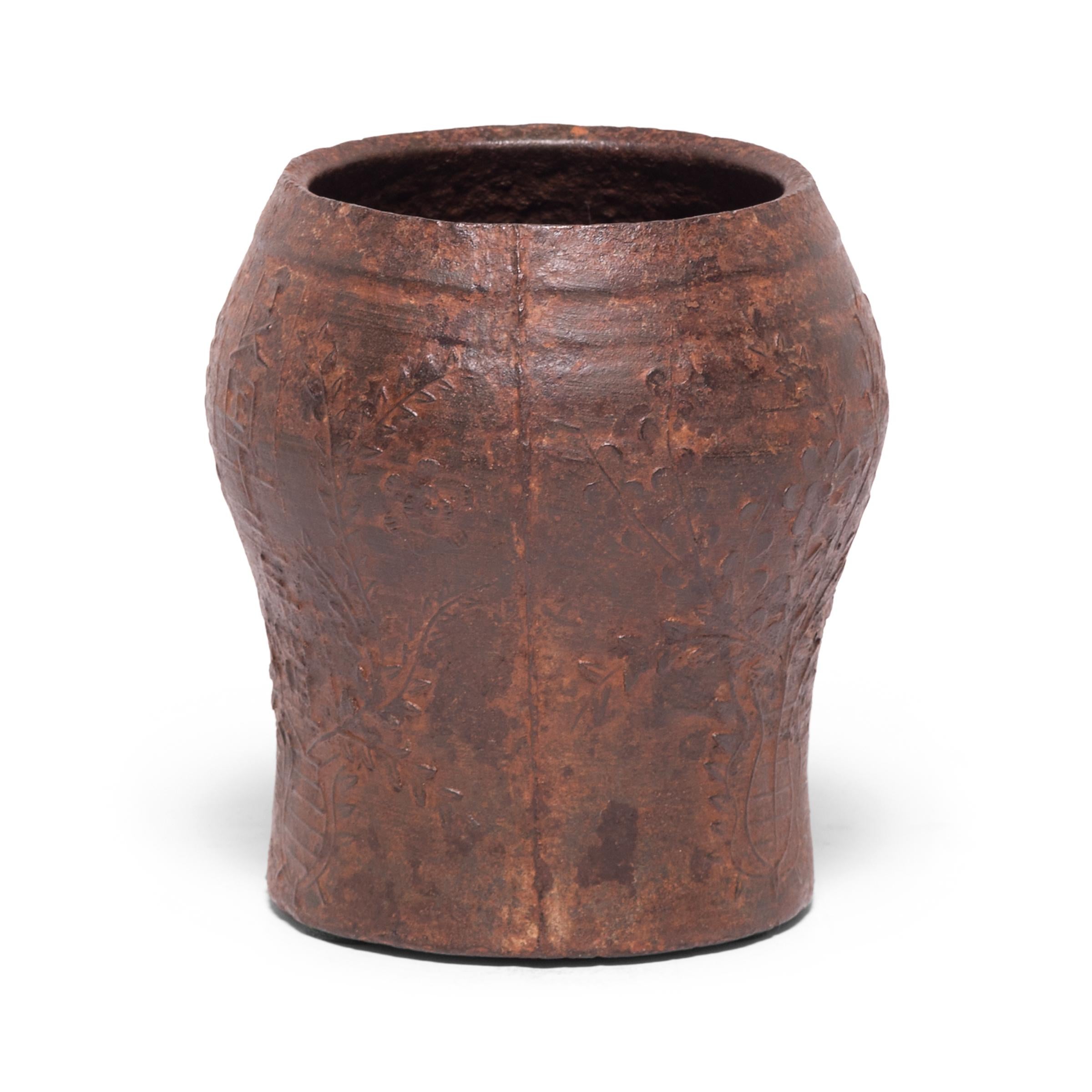 Cast in iron with a raised floral design, this vintage mortar was originally used in a traditional apothecary to create herbal medicines. The swelling shape allowed free movement of a pestle to effectively grind, mash, and macerate herbs and seeds
