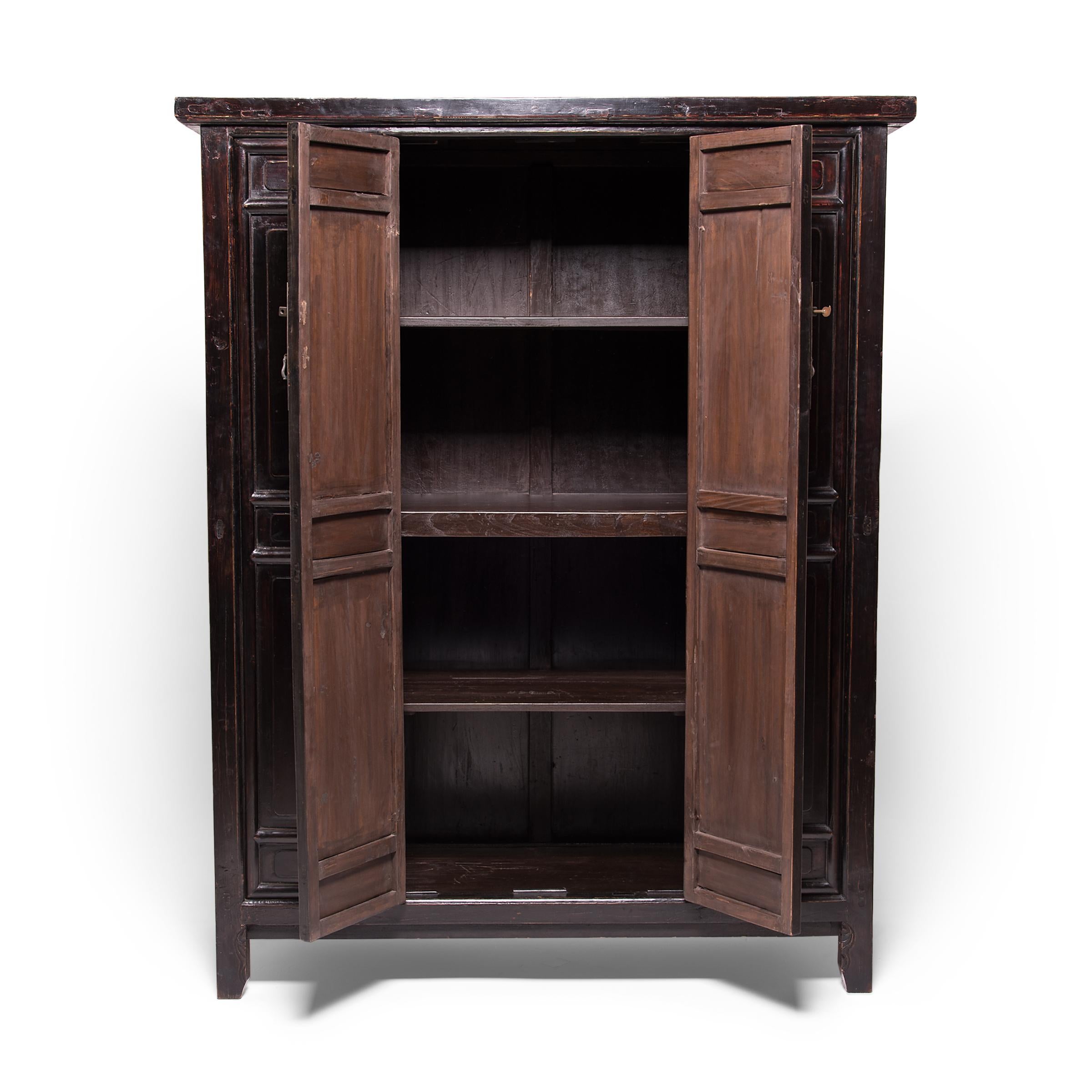 Beautiful in its austerity, this grand cabinet from China’s Shanxi province dates from the middle of the 19th century. Featuring two sets of bi-fold doors, the cabinet is elegantly carved with subtly detailed panels that are designed as 