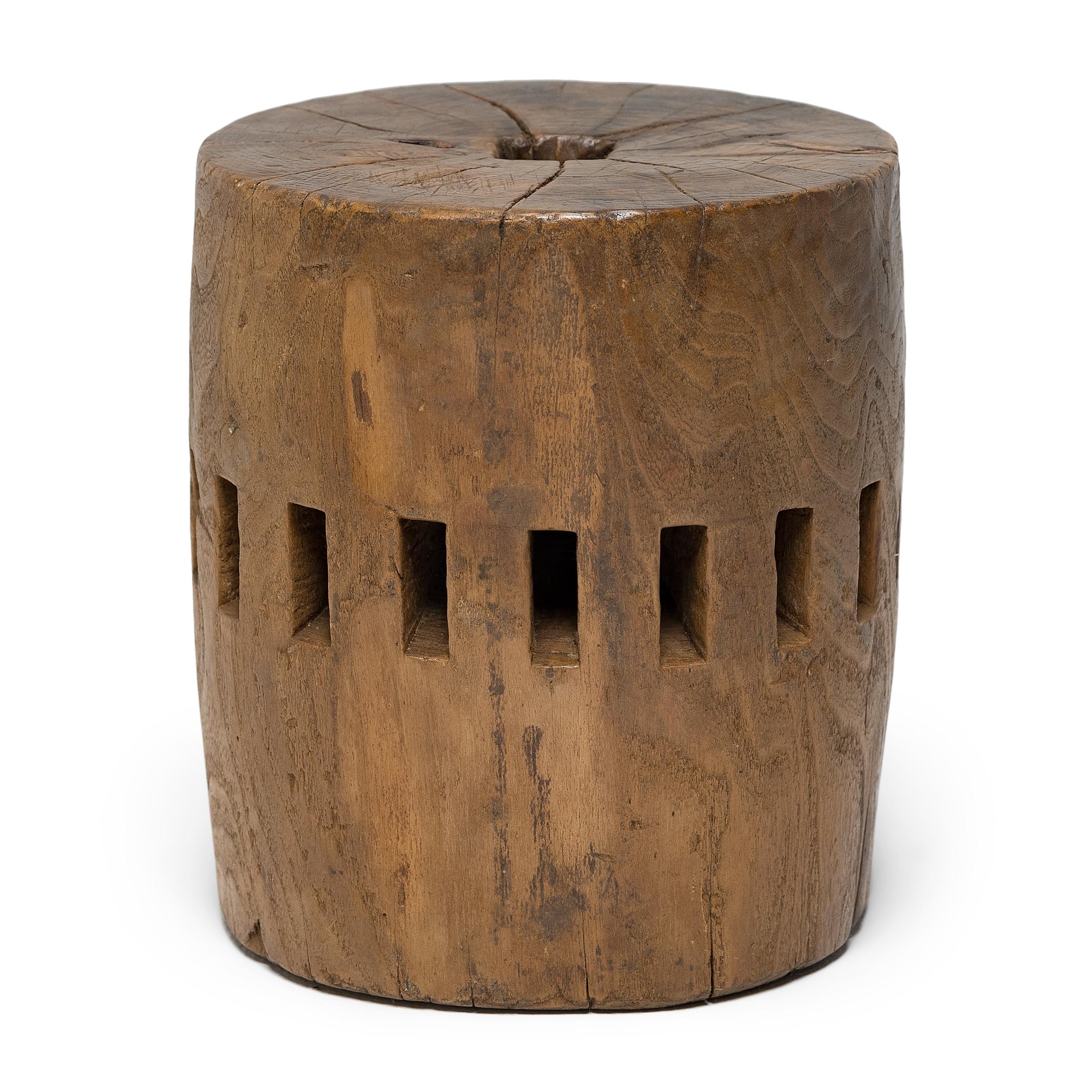 Carved from a single block of Elmwood, this unusual piece was once part of the central wheel shaft of a Qing-dynasty grain mill. Each slot once secured a peg of a large water wheel, which harnessed river currents to draw a millstone across grain
