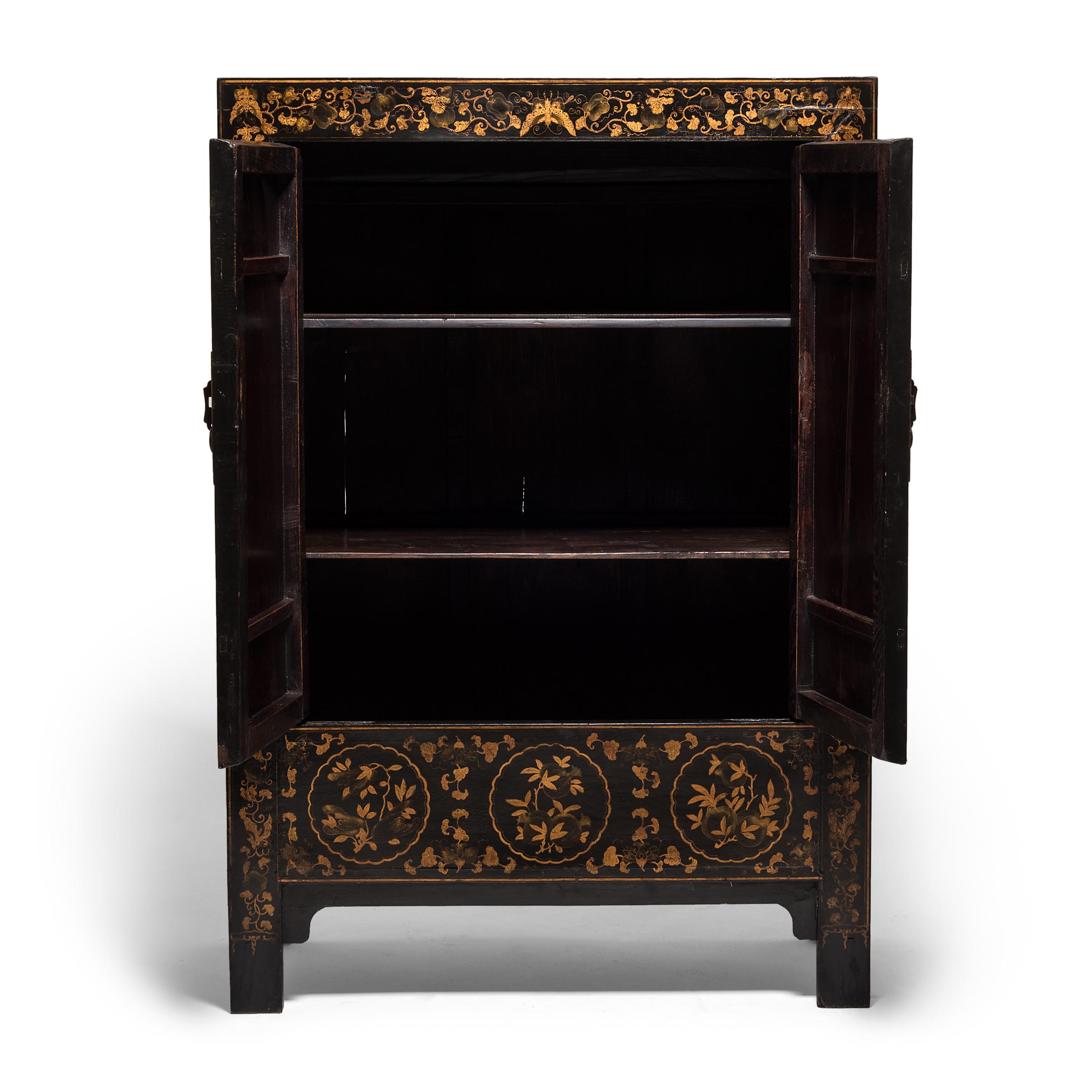 Seamlessly constructed and cloaked in black lacquer, this Qing-dynasty cabinet is spectacularly decorated with ornate gilt scenery, depicting traditional palatial courtyard buildings in a mountainous landscape. The grand spectacle is framed by a