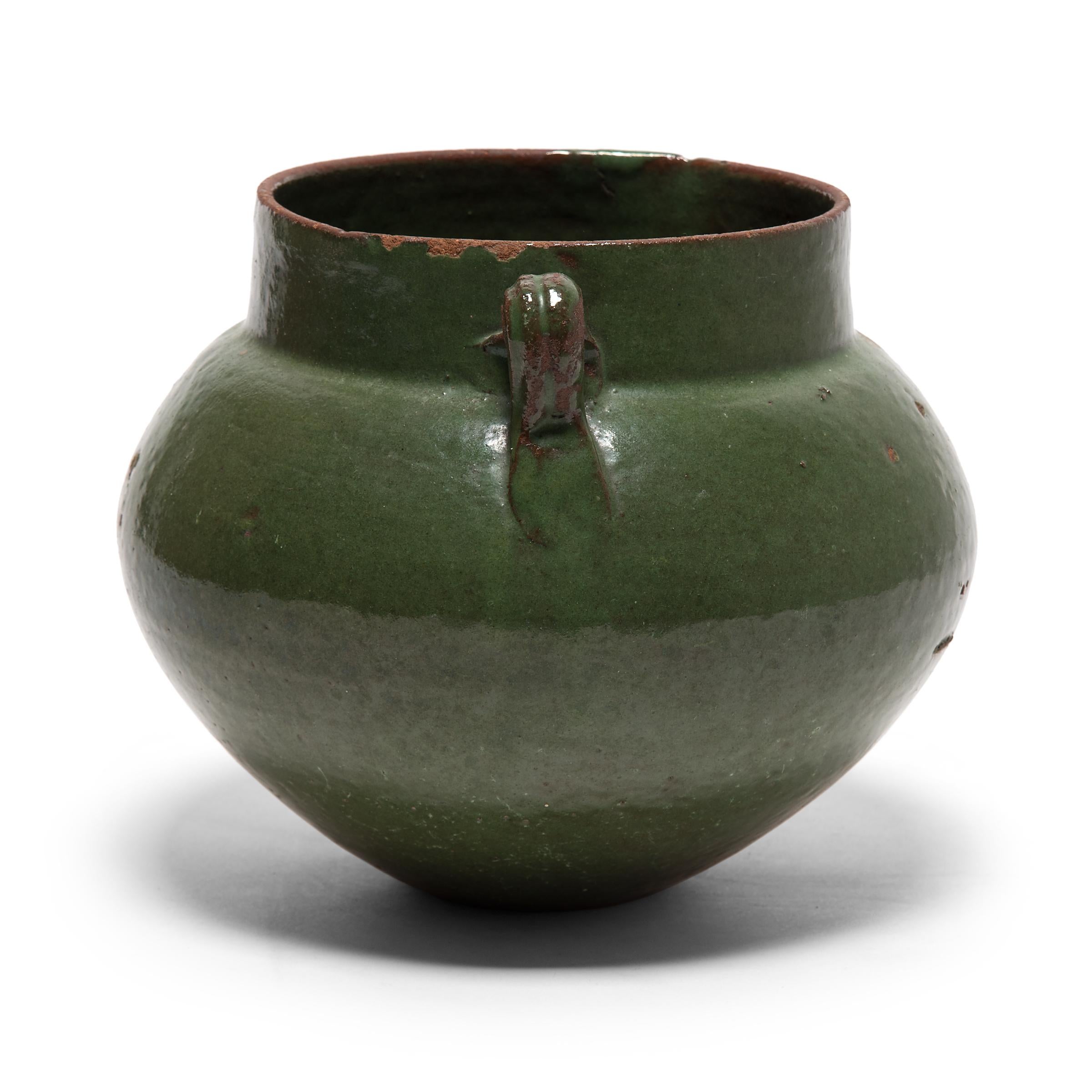 Tracing its roots back into the Han dynasty, this early 20th century vessel emulates the full-bodied shapes and unusual glazing found in ancient ceramics. Finely sculpted with thin walls, the jar has a squat, globular form that tapers from bulging