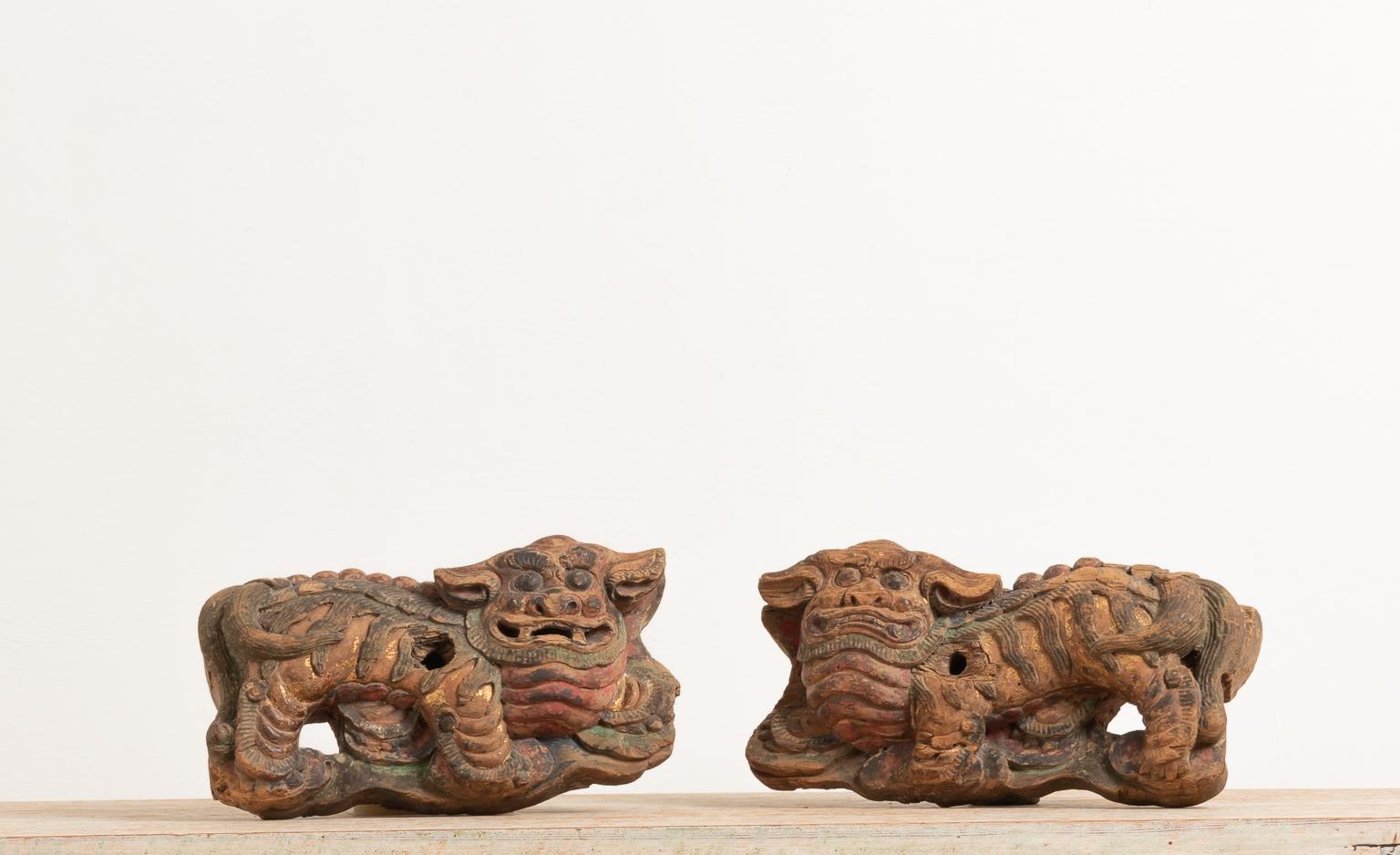 Chinese guardian lions in original condition. The lions are made from wood and were handmade sometime during the 19th century in China. The guardian lions are sometimes referred to as foo dogs or lion dogs and are thought to ward off evil sprits and