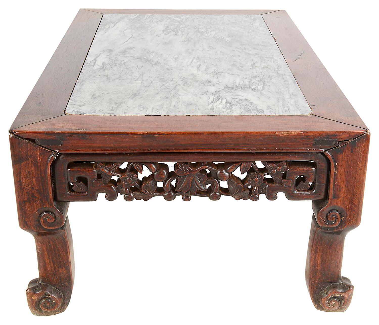 A good quality late 19th century Chinese hardwood Opium table or coffee table. Having an inset figured grey marble top, carved leaves and berries to the frieze and raised on four scrolling legs.