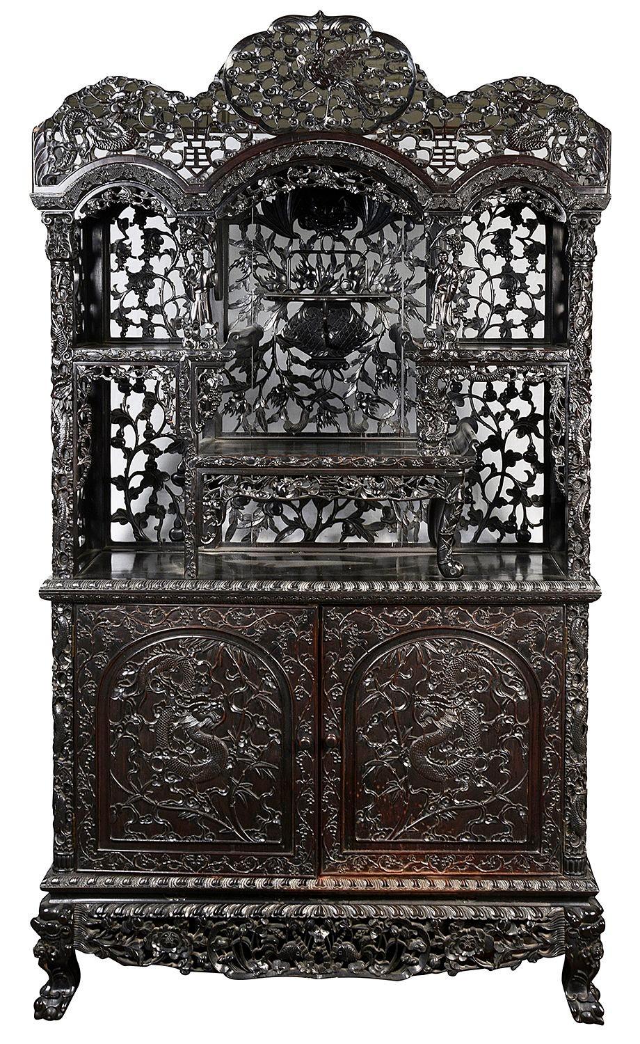 A fine quality 19th Century Chinese hardwood hand carved side cabinet. Having this wonderful shaped cornice with mythical carved Dragons and an exotic bird among clouds. Below are open shelves again with wonderful hand carved and pierced scrolling