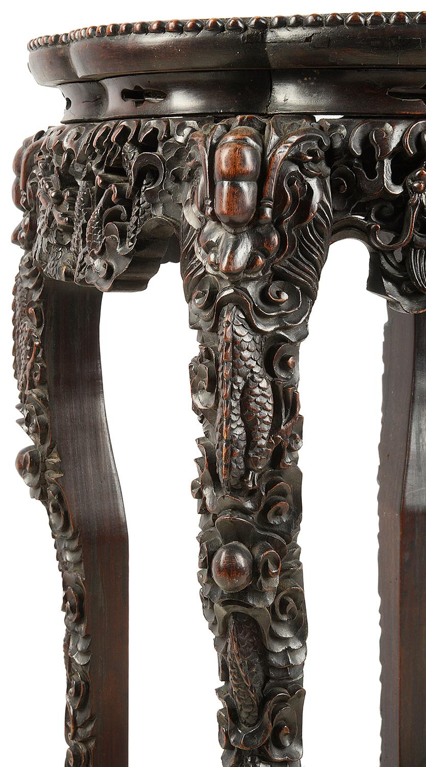 A very good quality 19th century Chinese hardwood stand, having an inset marble top, carved foliate decoration to the frieze and down the legs and a carved fret work under tier.