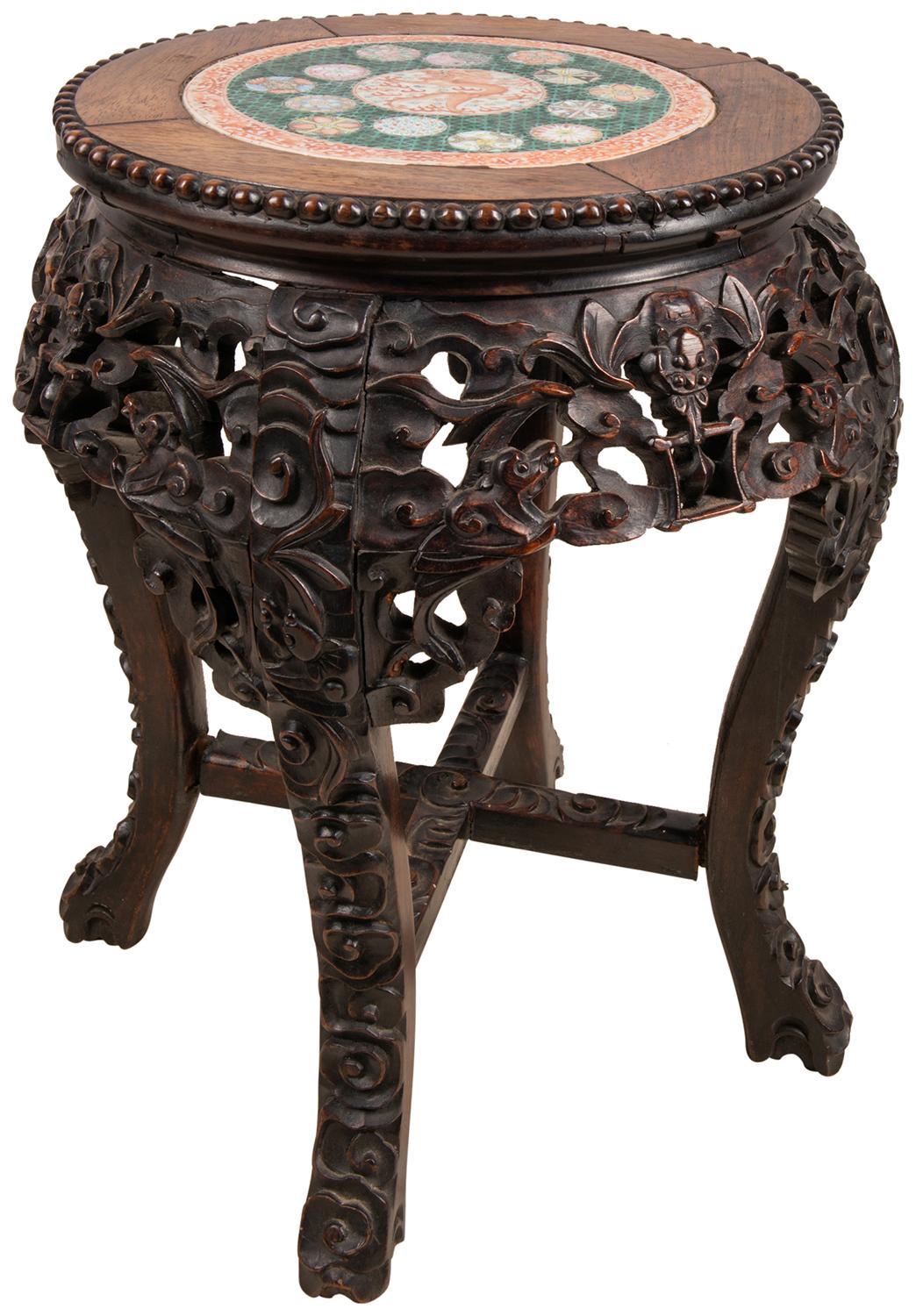 An unusual 19th century Chinese hardwood stand with hand carved foliate decoration, a Famille Verte porcelain plate inset to the center, depicting a mythical dragon, with a green ground boarder and classical motif symbols around.