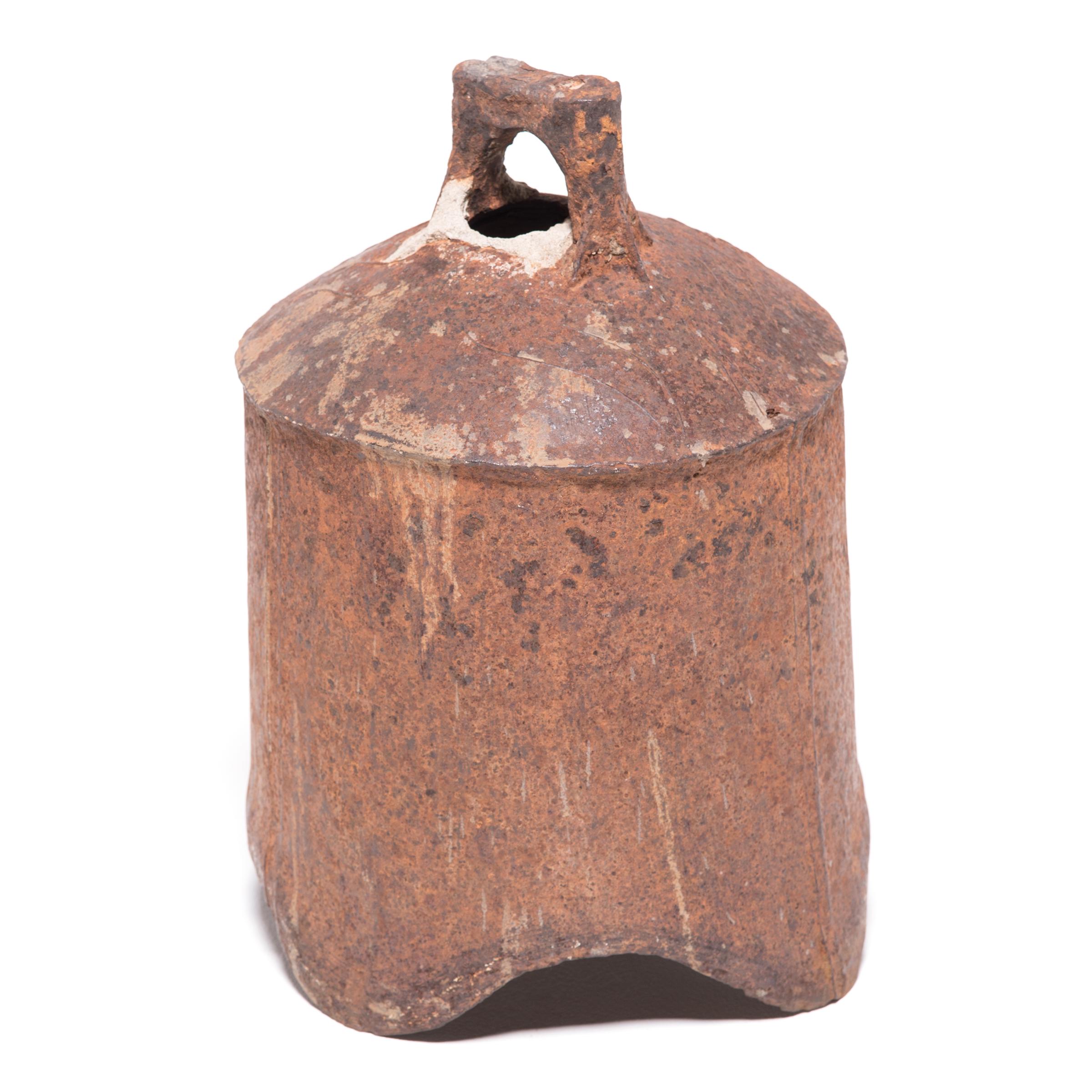 This rustic, 19th-century iron bell once pealed in celebration or gave notice of important events in a town in northern China. Marked with holes to affix the clapper or insert a pole, the bell looks lovely lit from within by a flickering candle or