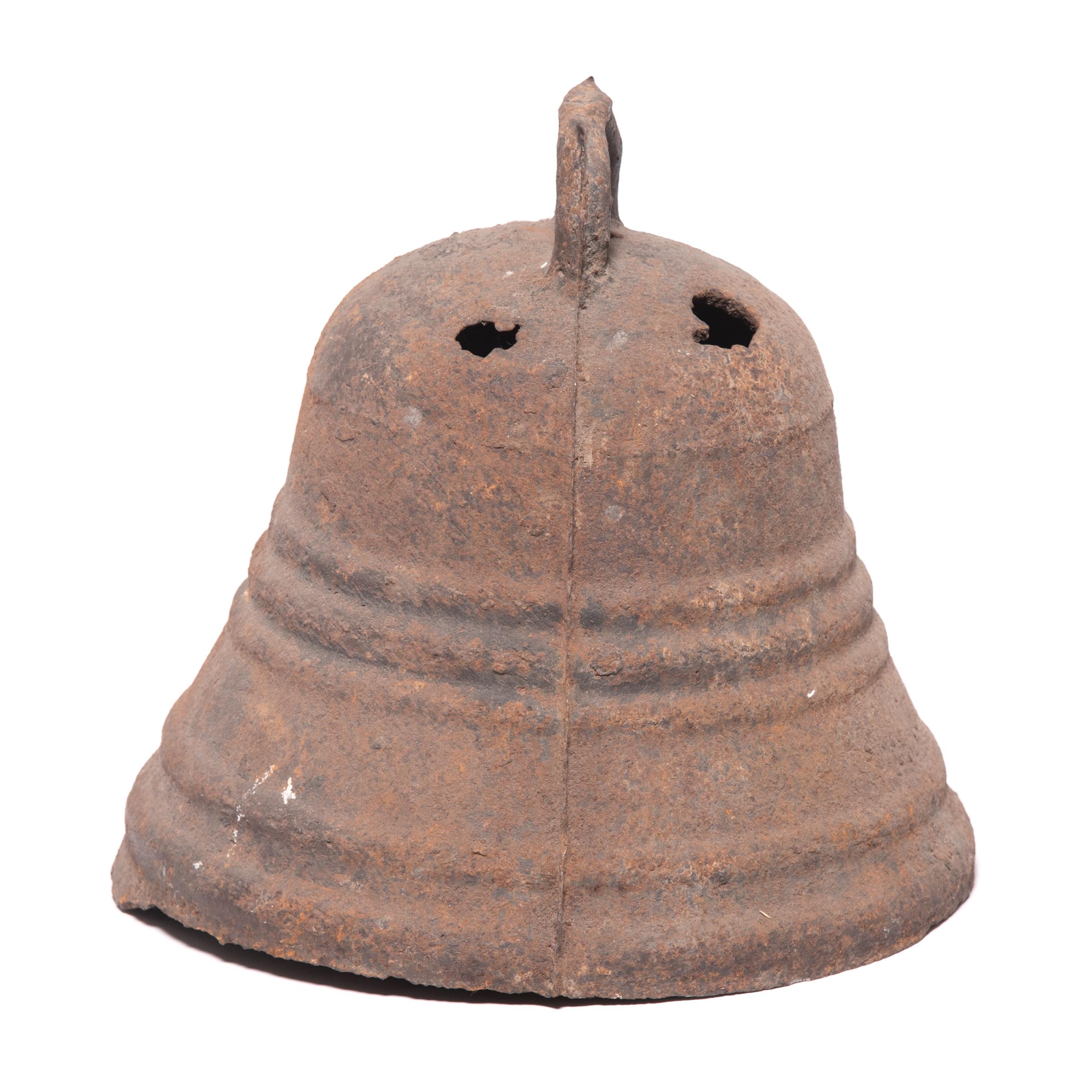 This rustic, 19th century iron bell once pealed in celebration or gave notice of important events in a town in northern China. The bell's wide mouth and ridged bead lines give this bell unique character, complemented by its fantastic textured