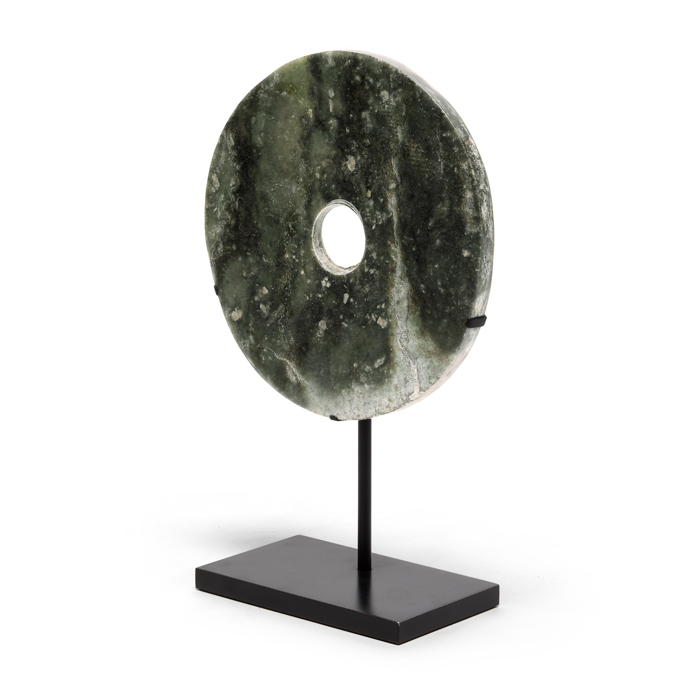Found in the tombs of ancient Chinese emperors and aristocrats, bi discs such as this have a mysterious and spiritual history, and their function and significance remain uncertain. Shaping this hard stone takes considerable skill. An artisan