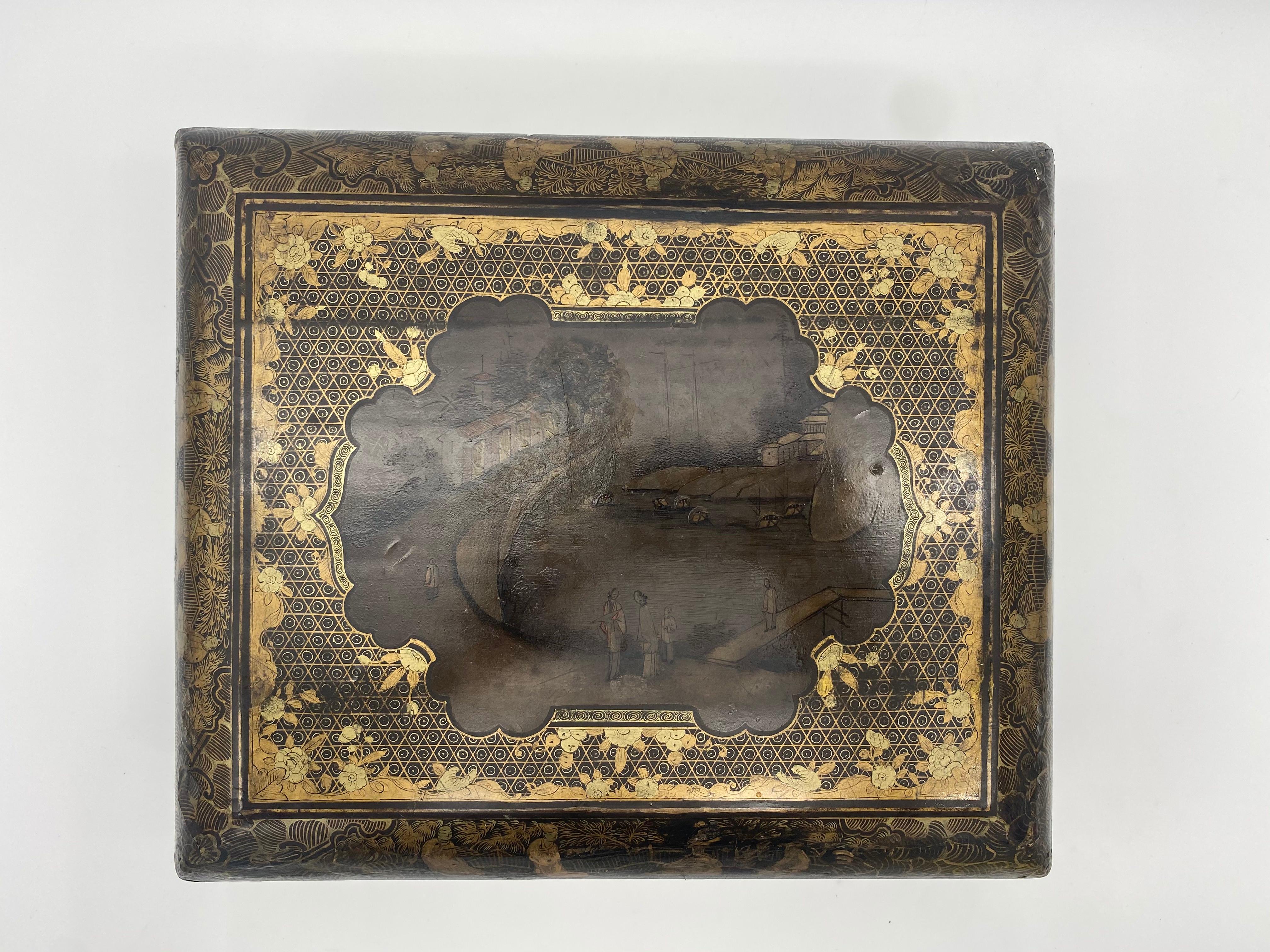 19th century Chinese export lacquer game box with gold decoration of landscapes with figures and houses, interior with boxes and trays, carved feet. Wear on the lacquer, see images for more detail.