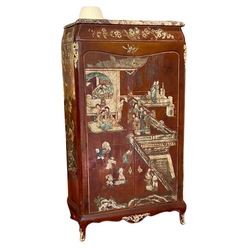 This unique Louis XV-style Chinese lacquer secretary desk from the late 19th century boasts a rich brown background, decorated with scenes of Oriental life – palaces, terraces, figures, birds, and floral motifs. It opens with one drop-down leaf, two