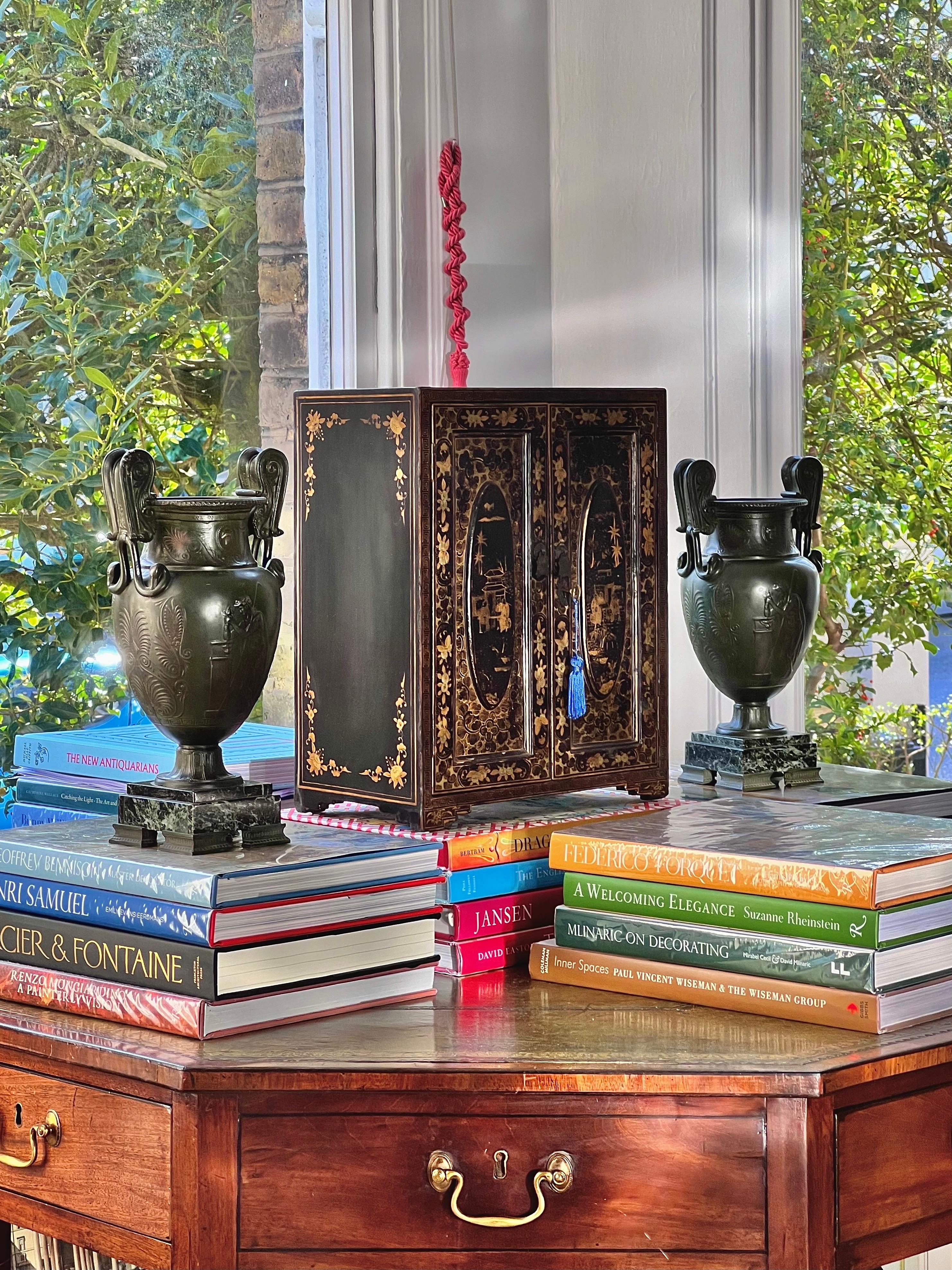 A striking black lacquer table or jewellery cabinet, exquisitely decorated with Oriental figures and pagodas throughout. Mid-19th century. A highly desirable and sought after model.

This exceptional cabinet serves as both a practical storage piece