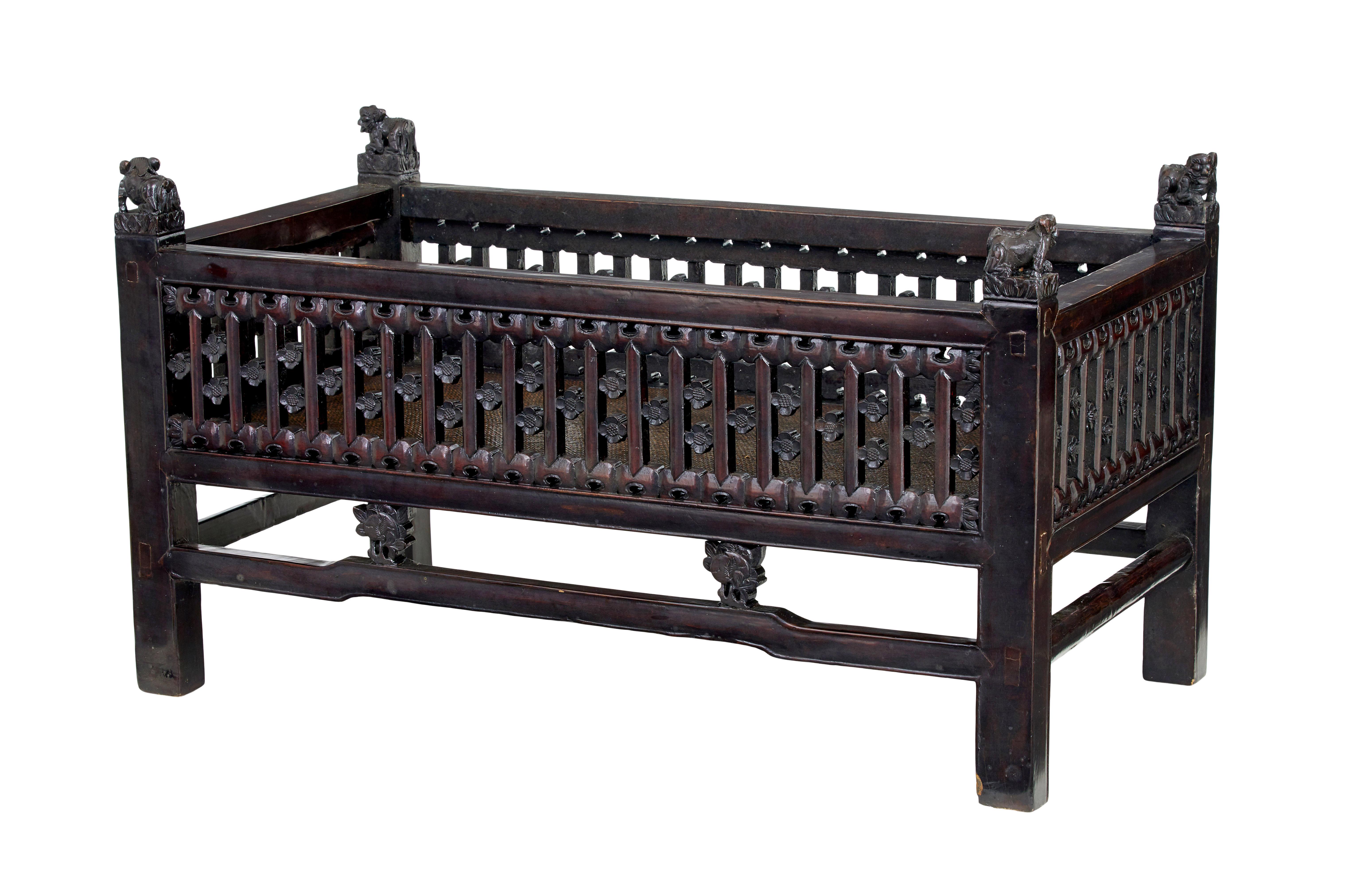 19th century Chinese carved hardwood bed circa 1890.

Chinese export which we believe may have been made as a child's bed. Carved pierced sides decorated with flowers.  Each corner with a carved dof of fo.  Hard rattan base.

In today's age it could