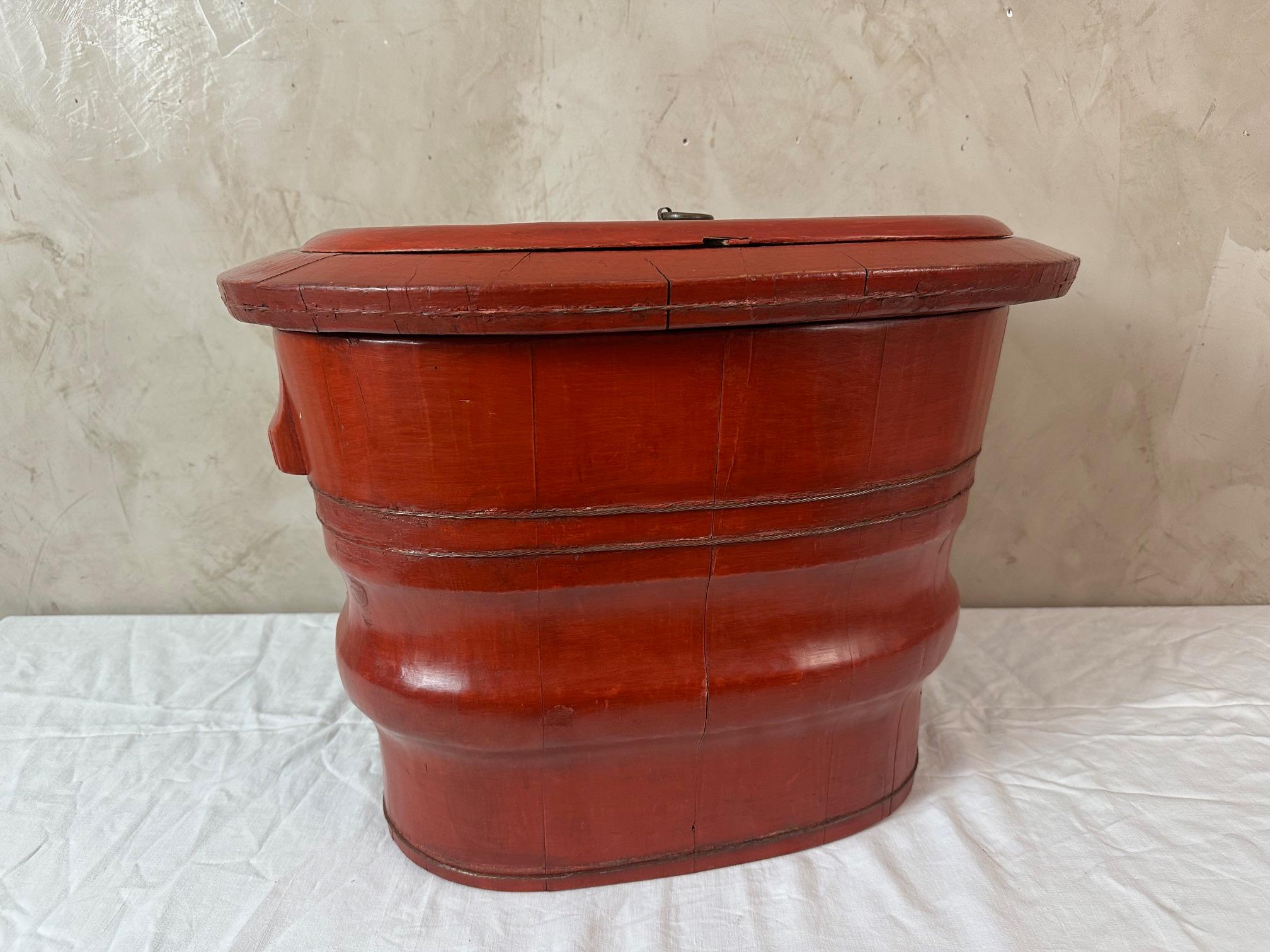 An original item! An antique Chinese baby bathtub dating from the late 19th century. Made of red lacquered elm. This bathtub consists of two compartments: the large reservoir for storing water and the upper part for placing the baby. A lid with a