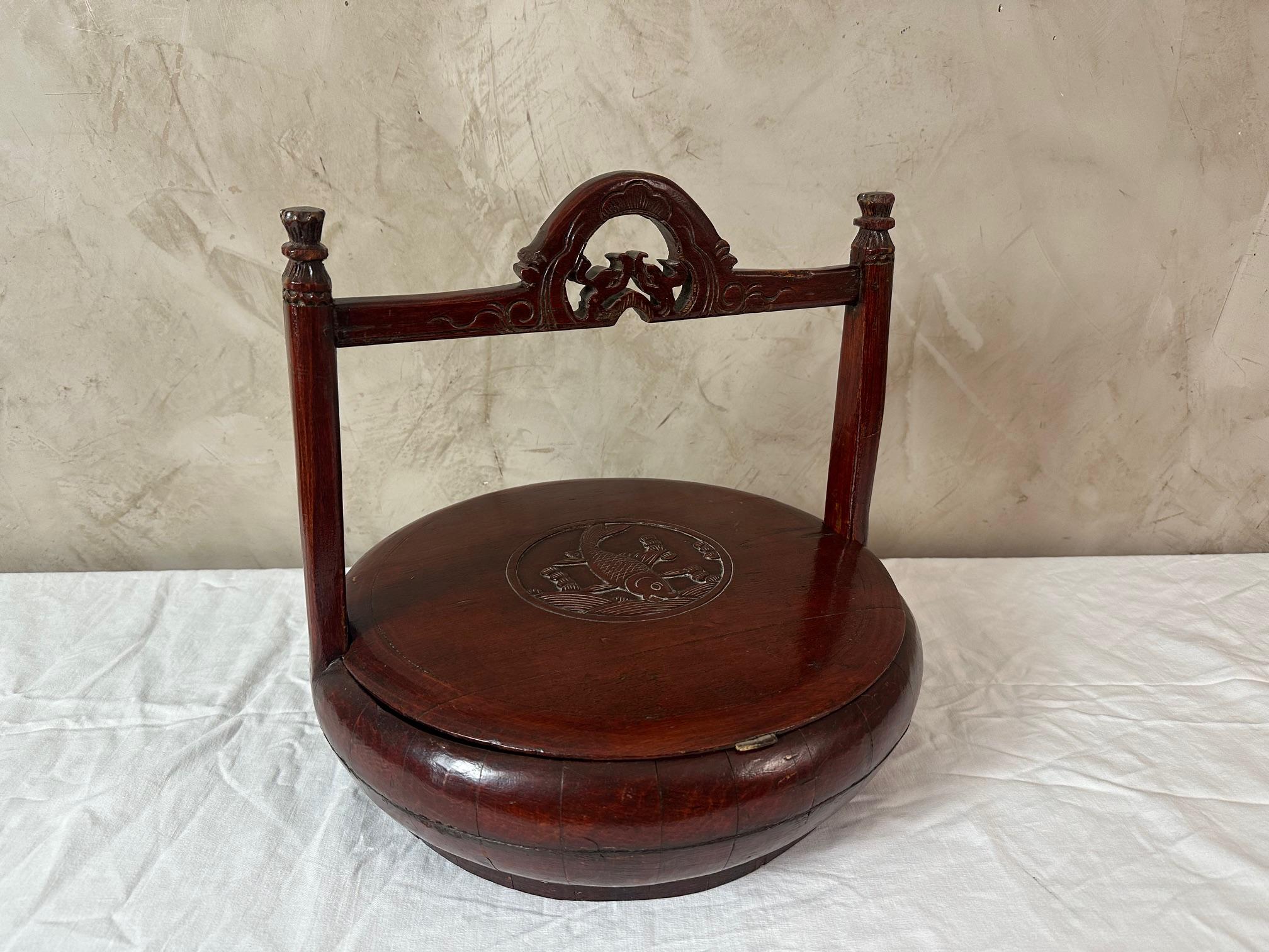 Ancienne boîte à lunch chinoise en orme laqué, datant du 19e siècle, faite à la main. Utilisé par les travailleurs des rizières. Couvercle amovible avec un motif de poisson sculpté à la main.
La poignée présente également des détails sculptés.