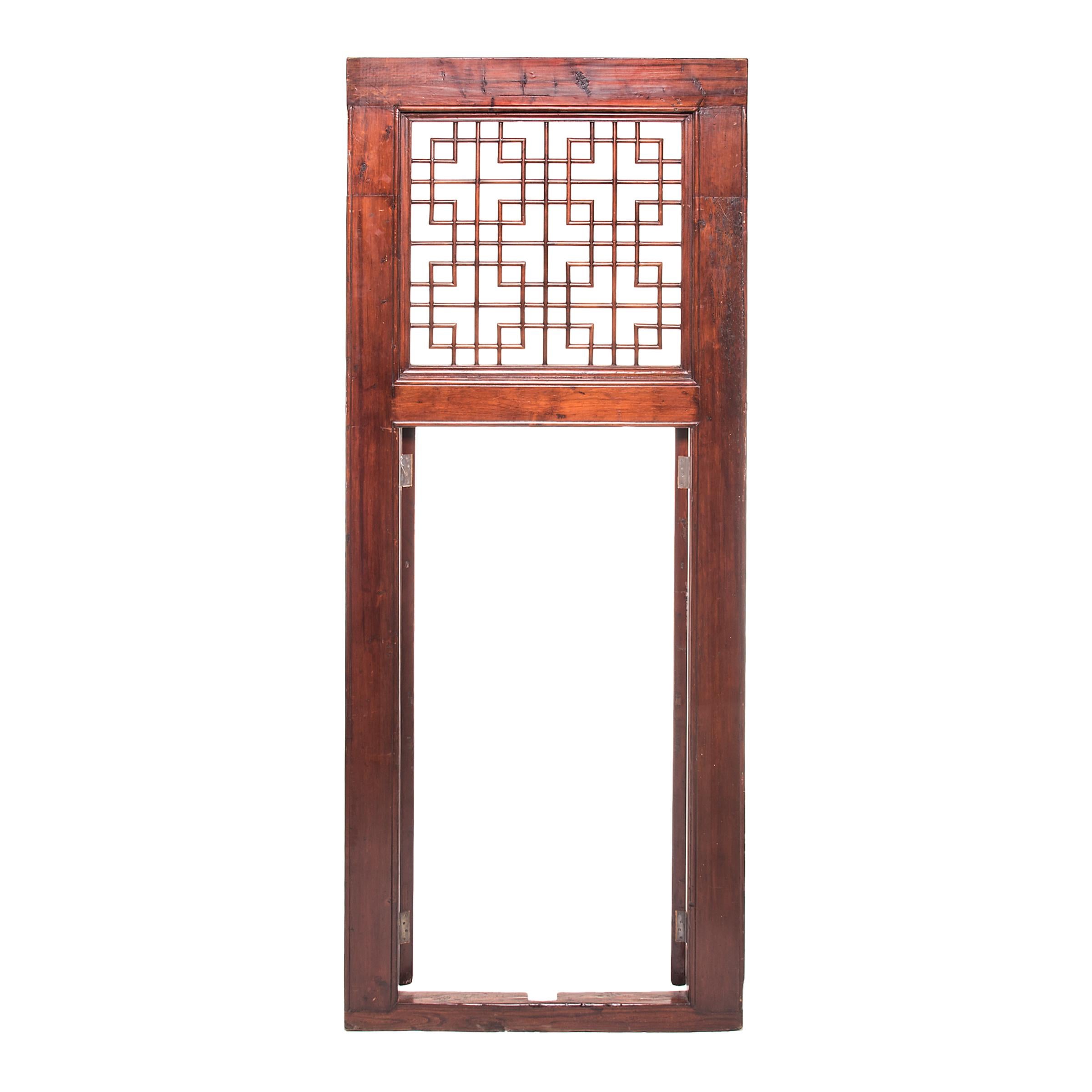 A hallmark of Qing-dynasty domestic architecture, hand carved lattice doors such as this one were used in provincial courtyard homes to allow light and air into a room while maintaining privacy. Graced with vertical brass pulls, two latticed doors