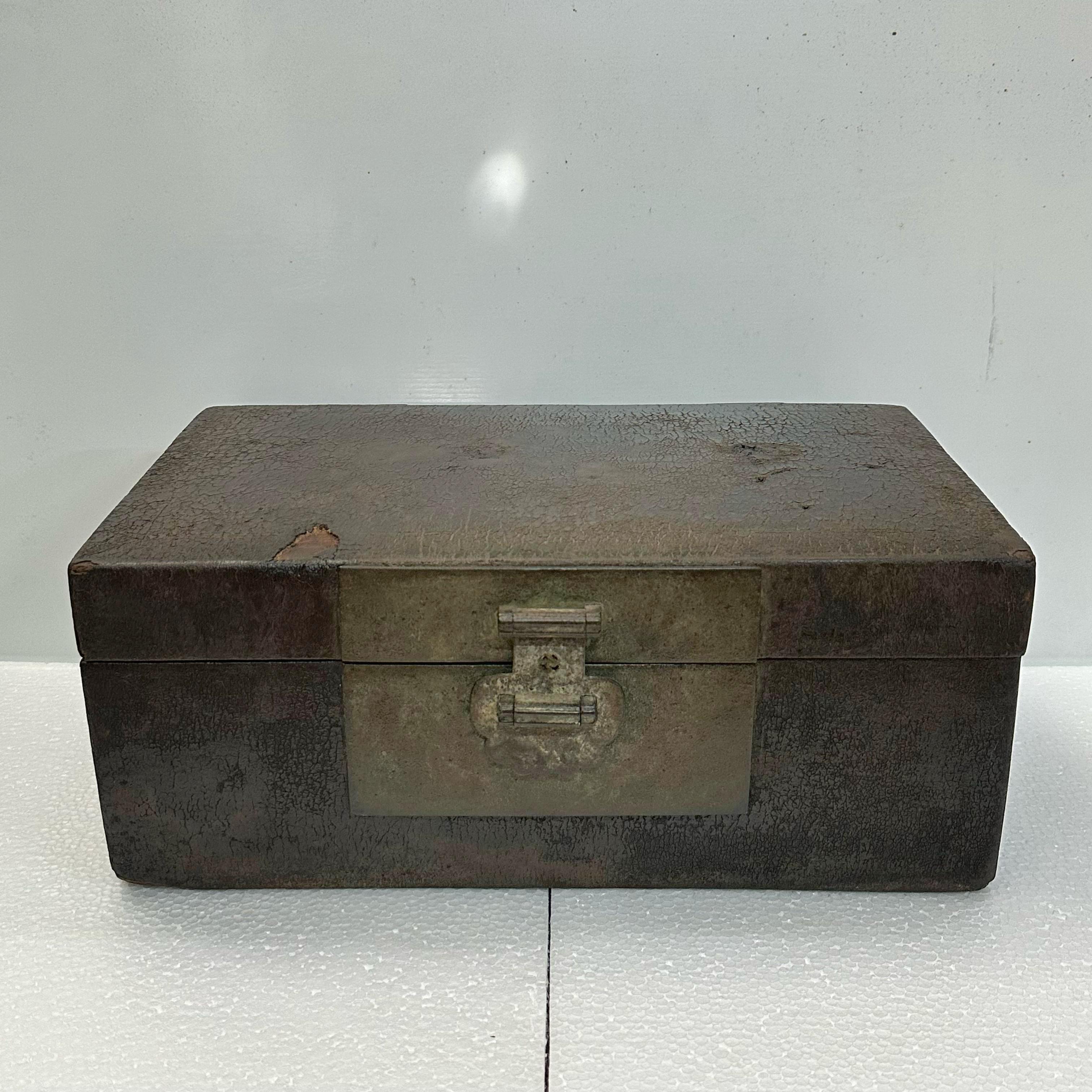 This antique leather box from Shanxi province has an original dark, almost black, exterior, and a deep maroon leather interior. The characteristic cracked leather texture throughout the surface is consistent with its age.
Its original brass handles