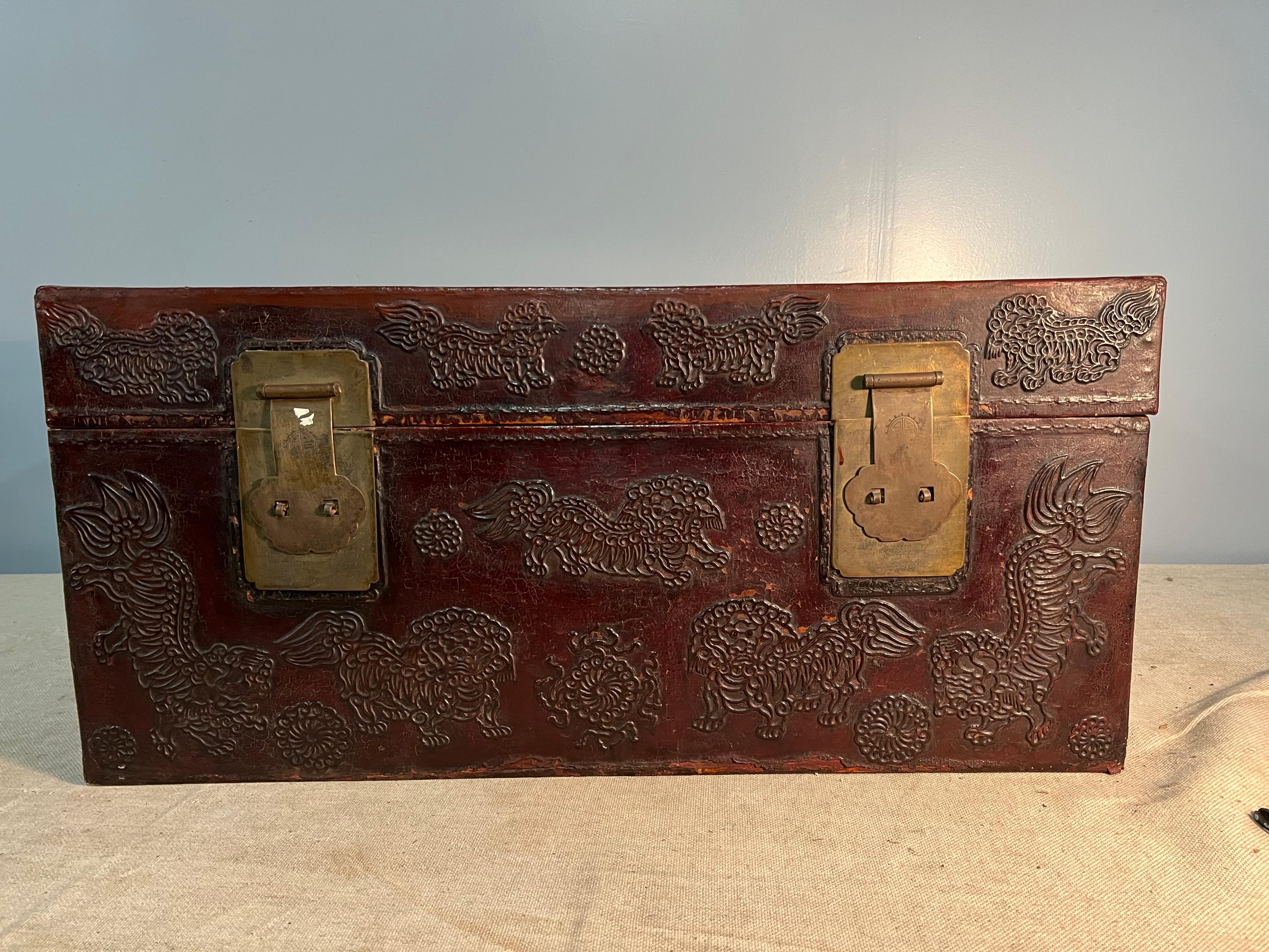 A 19th century Chinese lacquered leather trunk with bronze hardware and raised decoration. This decorative trunk has a beautiful old patina and is great for storage.