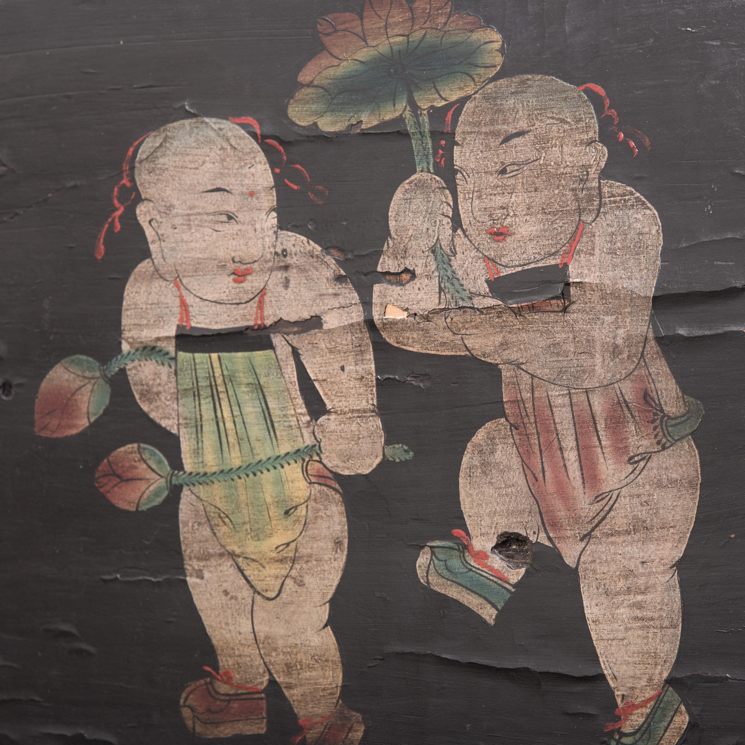 Created during the Qing dynasty, this hand painted panel once concealed a compartment within a large cabinet. To the delight of its owners, each time the cabinet door was opened they were greeted by the image of these two charming young boys